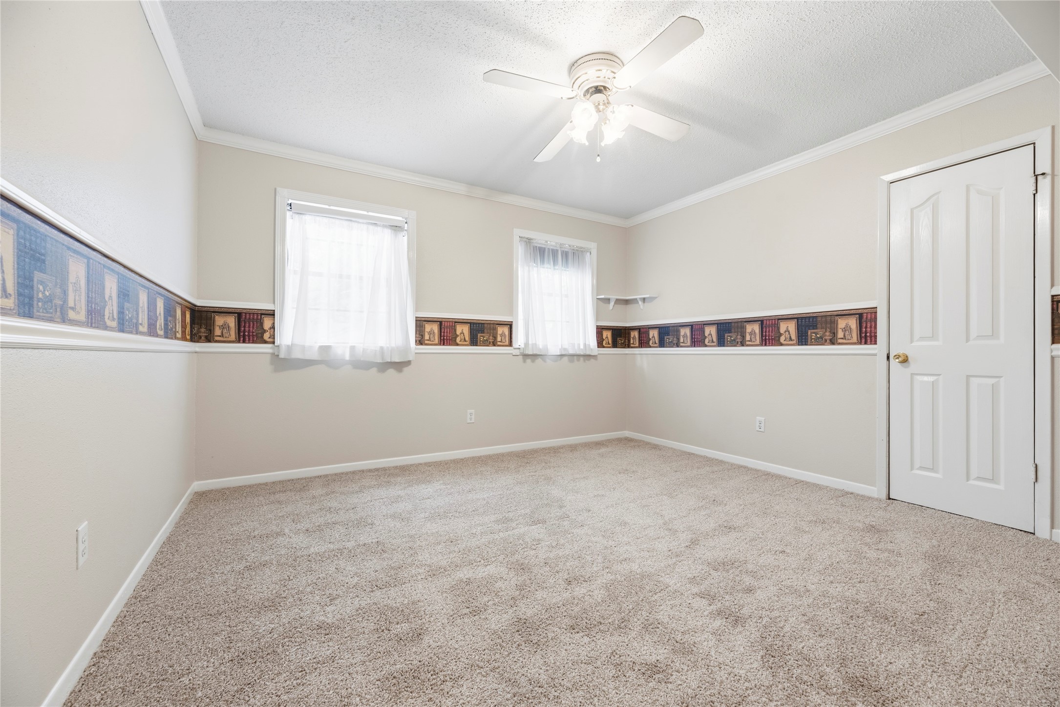 Spacious bedroom located upstairs complete with a ceiling fan and plush carpet.