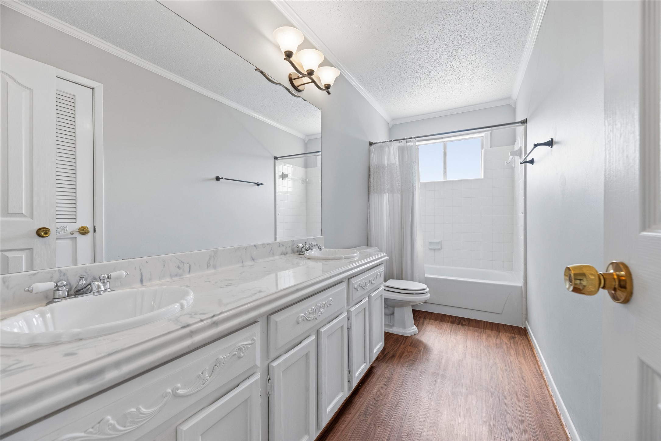 Spacious secondary bathroom located upstairs with dual sinks and a shower/tub combo.