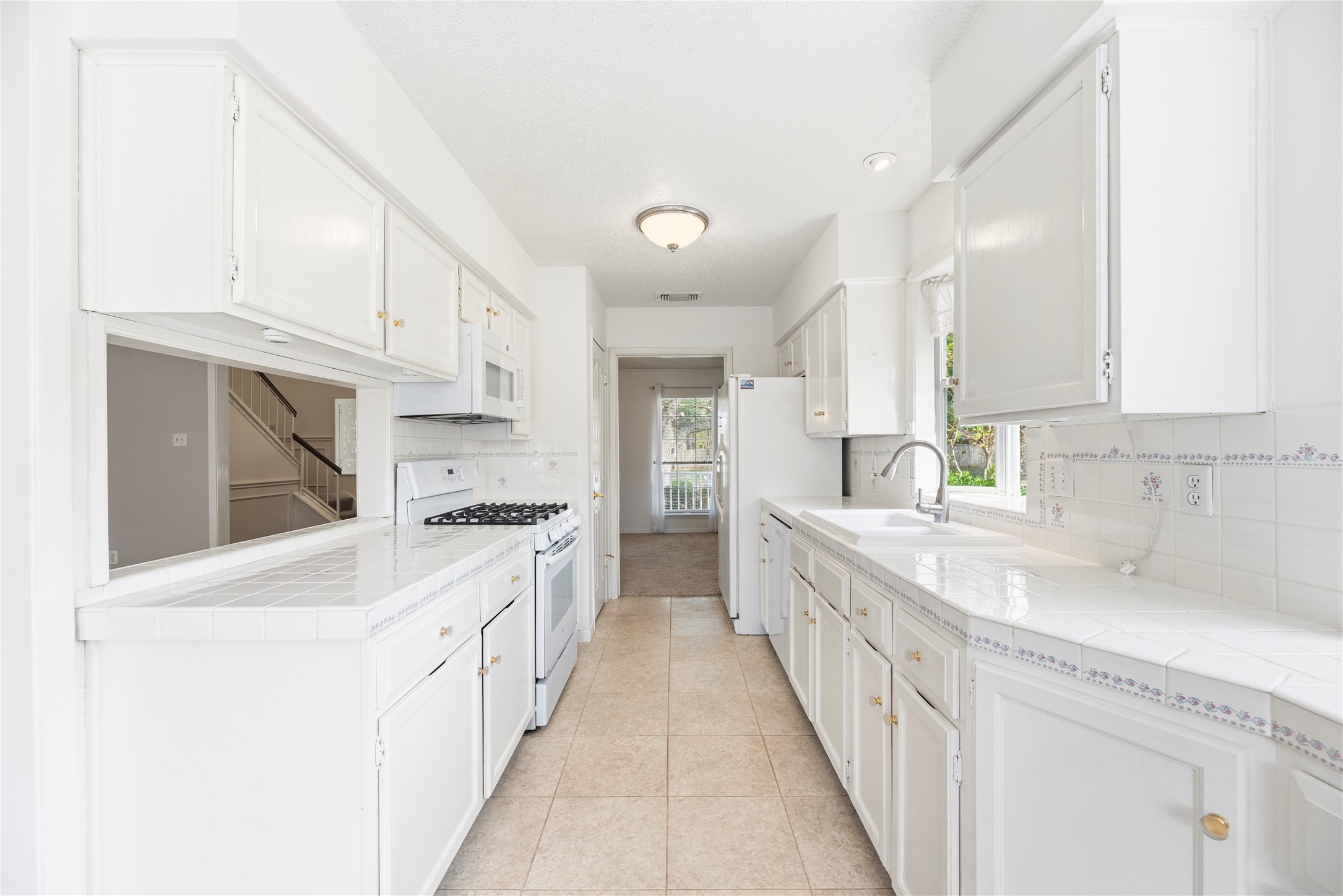 Light and bright kitchen with an abundance of countertop and cabinet space, updated appliances including a gas range.