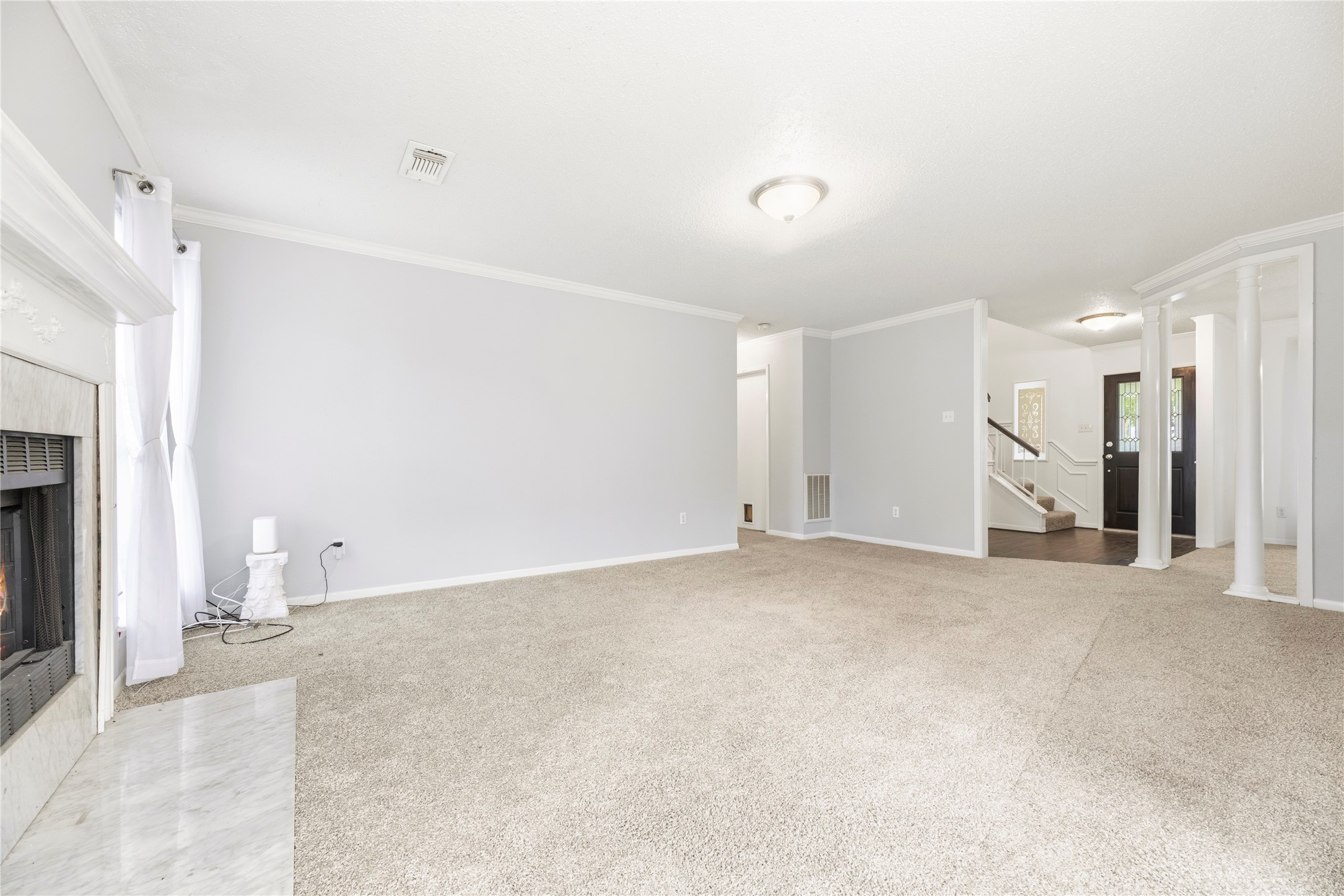 Spacious living room with fresh paint, brand new carpet, fireplace and large windows for natural light.