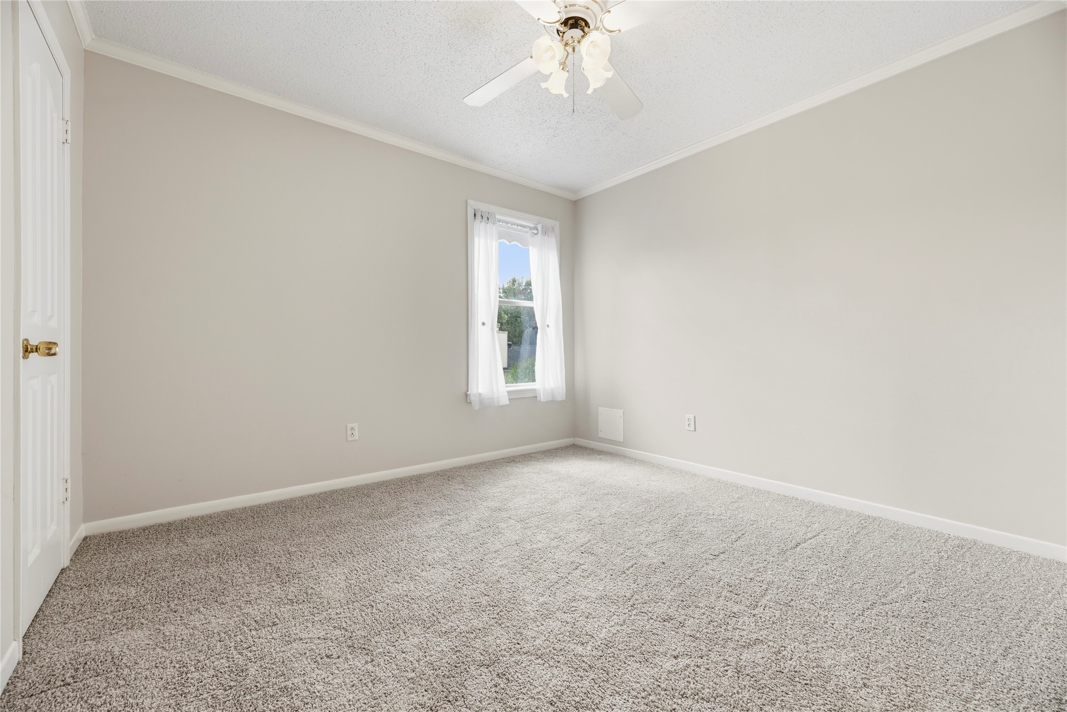 Spacious bedroom located upstairs complete with a ceiling fan and plush carpet.