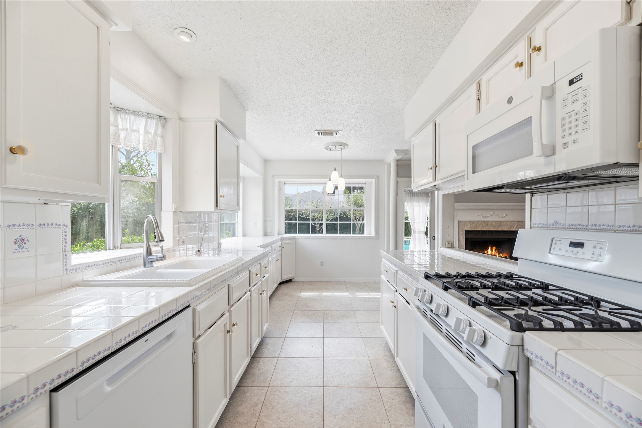 Light and bright kitchen with an abundance of countertop and cabinet space, updated appliances including a gas range.