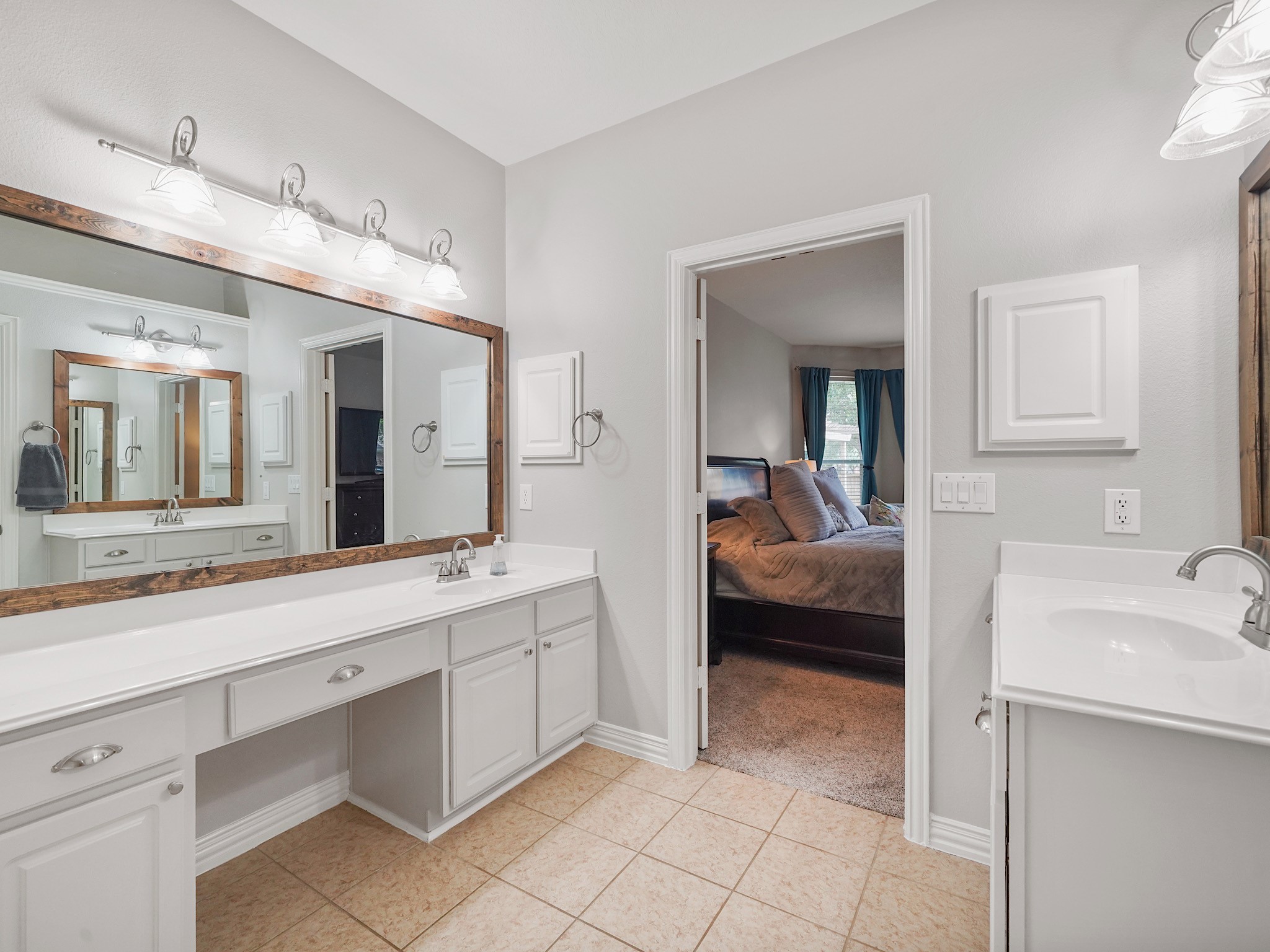 Dual sinks, a dedicated vanity area, and abundant cabinetry provide plenty of room for busy mornings.