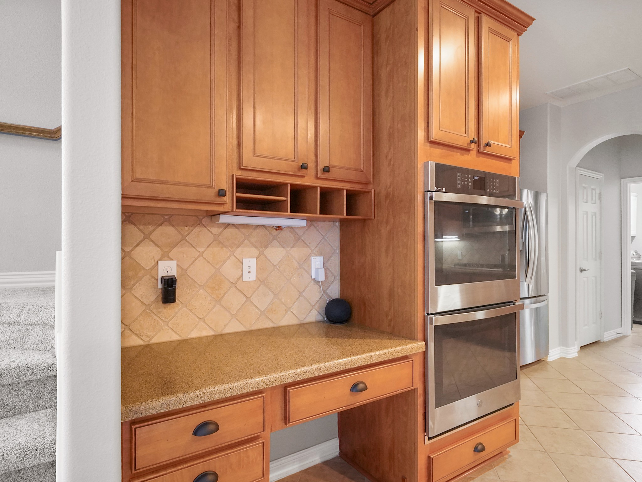 Tucked beside the secondary staircase, this built-in workstation creates the perfect command center for household organization, homework, or remote work.