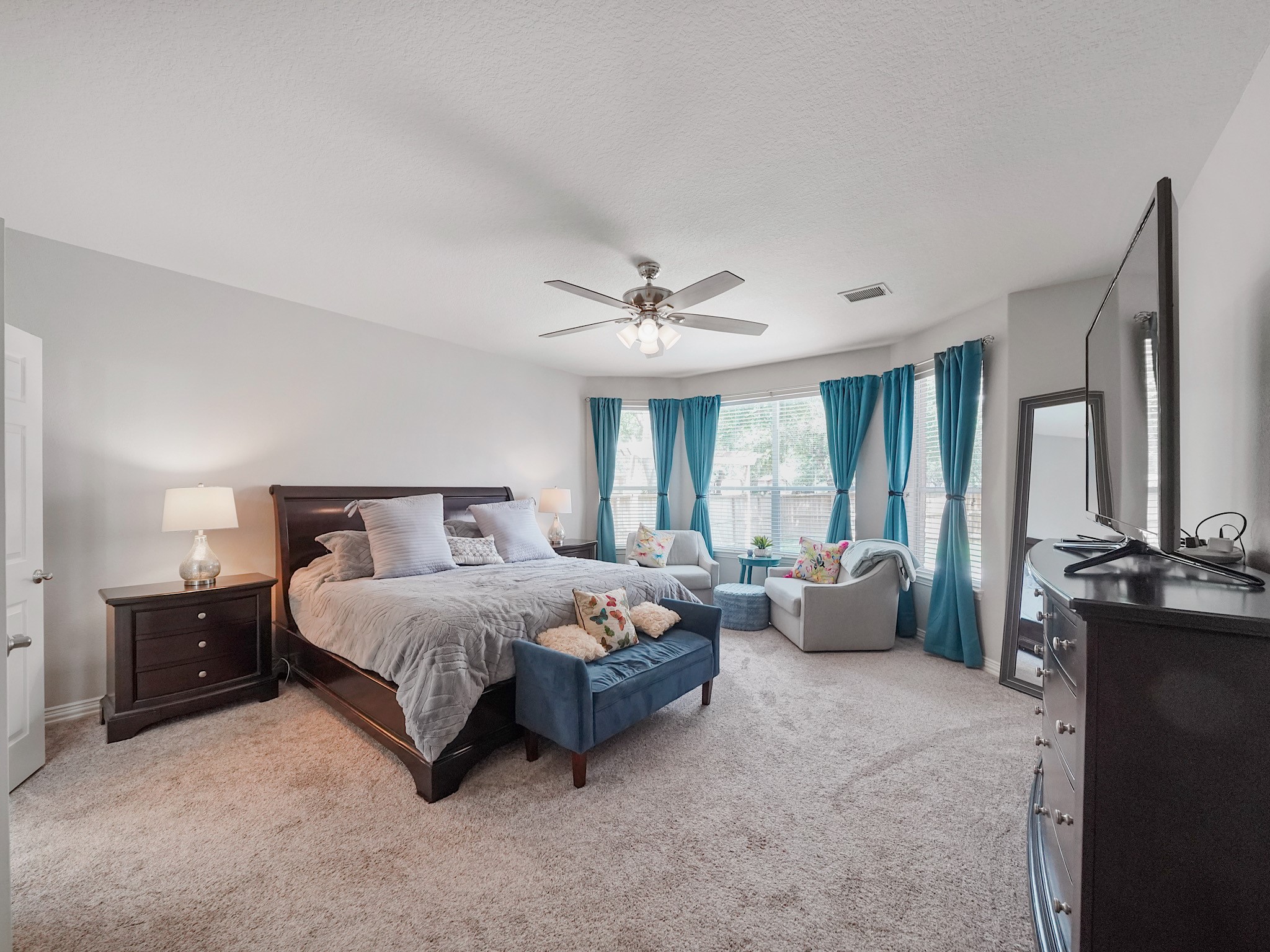 Privately situated on the first floor, the spacious primary suite offers a peaceful escape with beautiful bay windows and room to unwind.