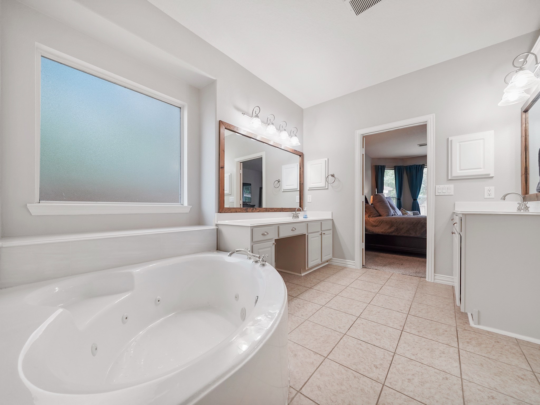 The spa-inspired primary bath invites relaxation with a jetted soaking tub, expansive vanity space, and a bright, open design.