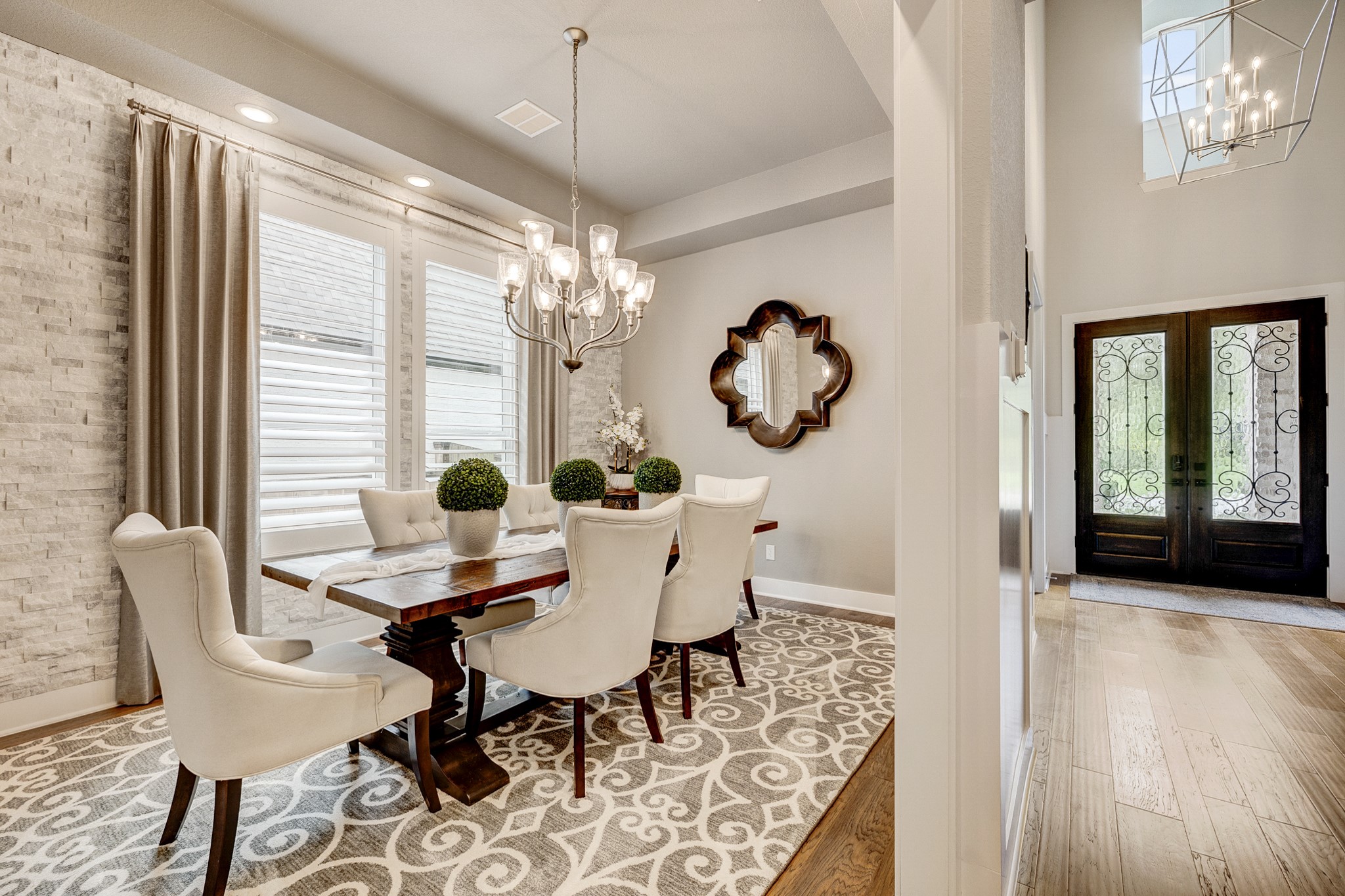 The dining room features a sophisticated stone accent wall complemented by elegant plantation shutters. The dining room features a sophisticated stone accent wall complemented by elegant plantation shutters.