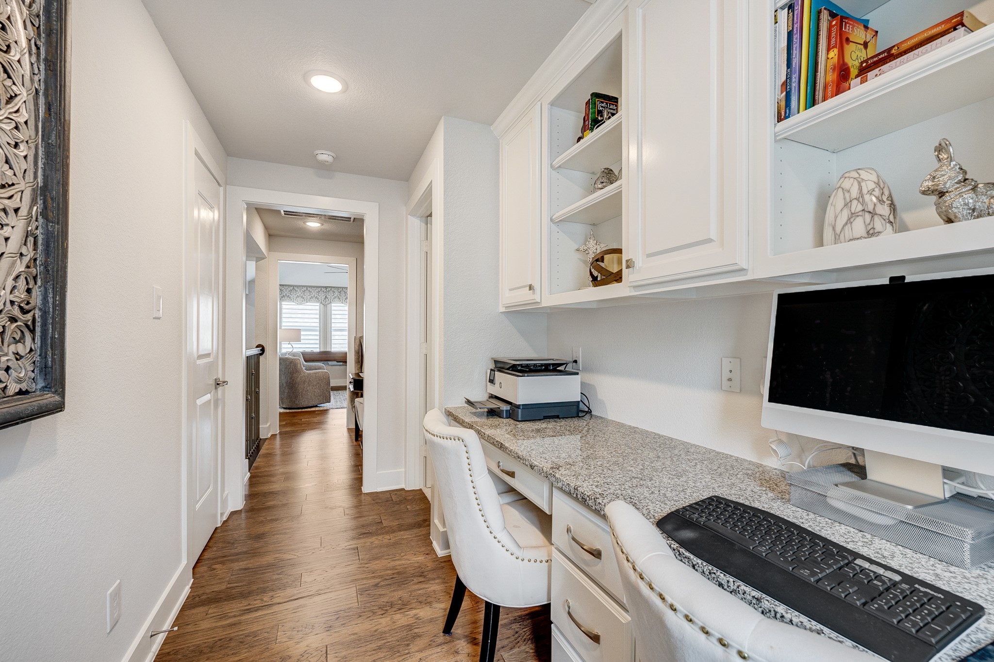 Beautiful wood flooring throughout, featuring a functional desk area, custom cabinetry, and built-in shelving for maximum storage efficiency.