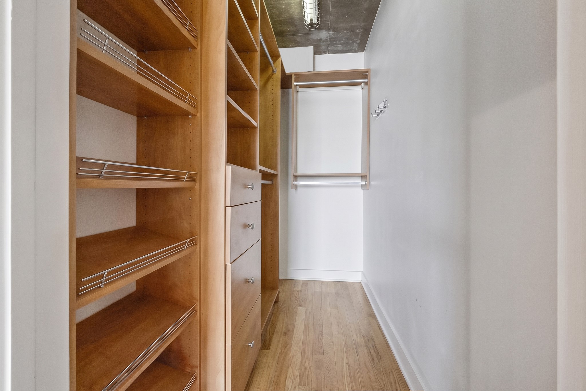 The walk-in closet features a custom California Closets organization system with open shelving, hanging space, and dedicated storage compartments. A thoughtful addition that maximizes storage within the residence.