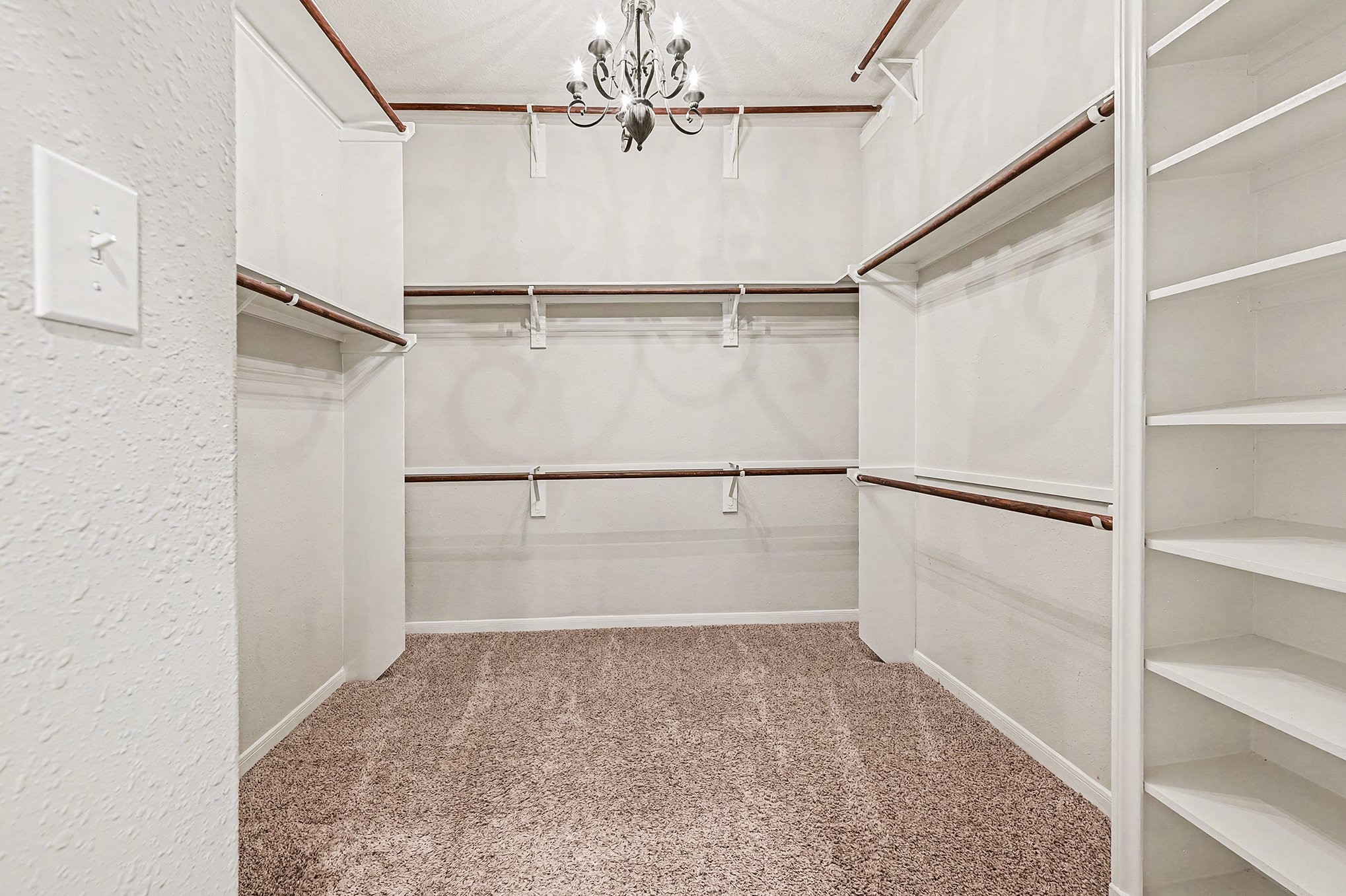Look at 1 of 2 closets In Primary Bathroom (10.5 x 10.5) lots of shelfing, hanging space for all clothes and shoes with a chandlier for lighting.