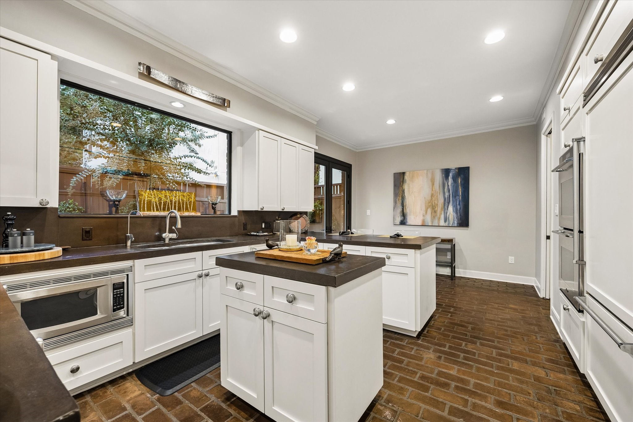 Welcome to the Kitchen featuring updated cabinets and counters, and brick floors.