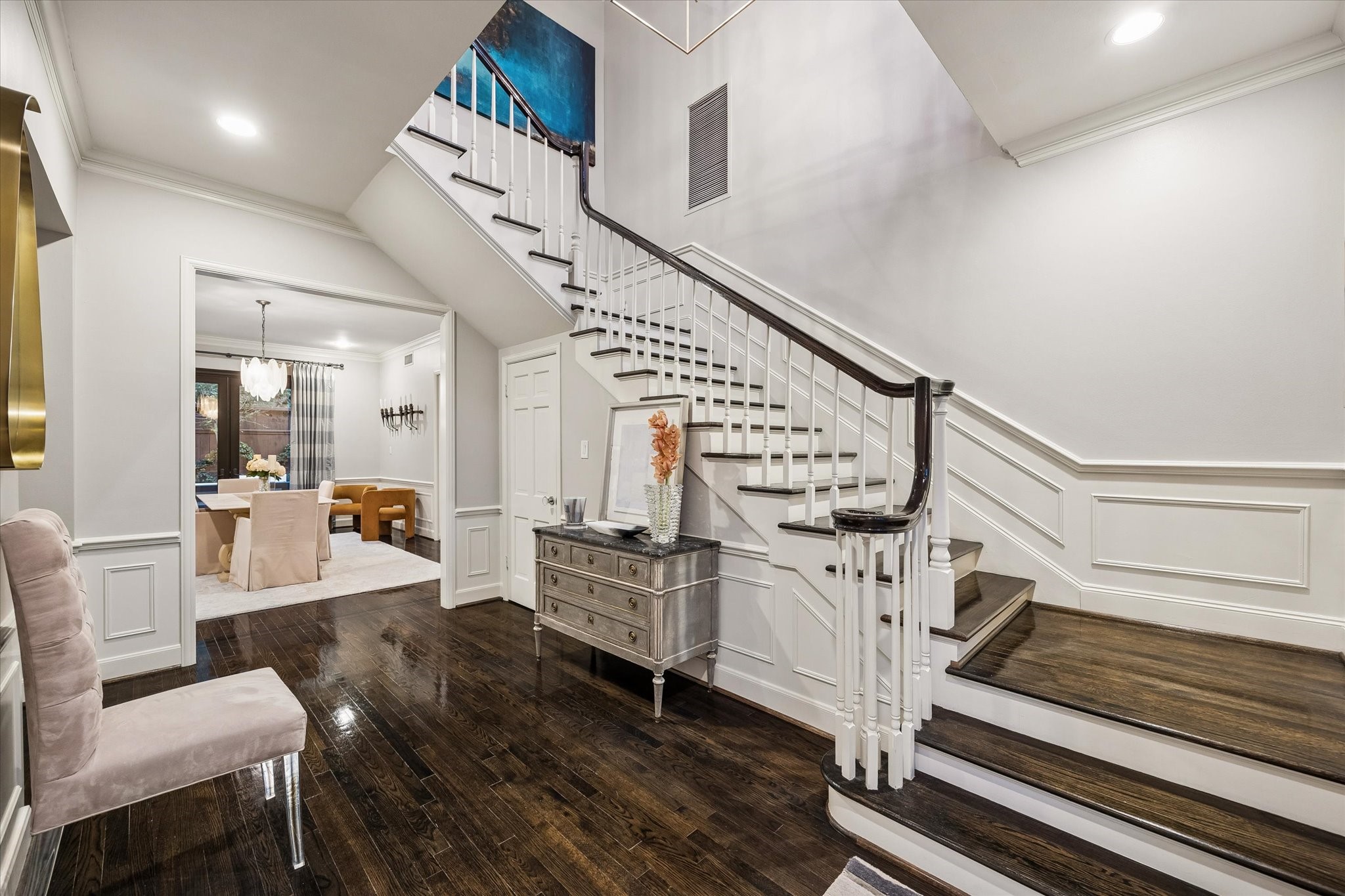 The sweeping staircase adds drama to the home with bounteous wall space and glimmering hardwood floors.