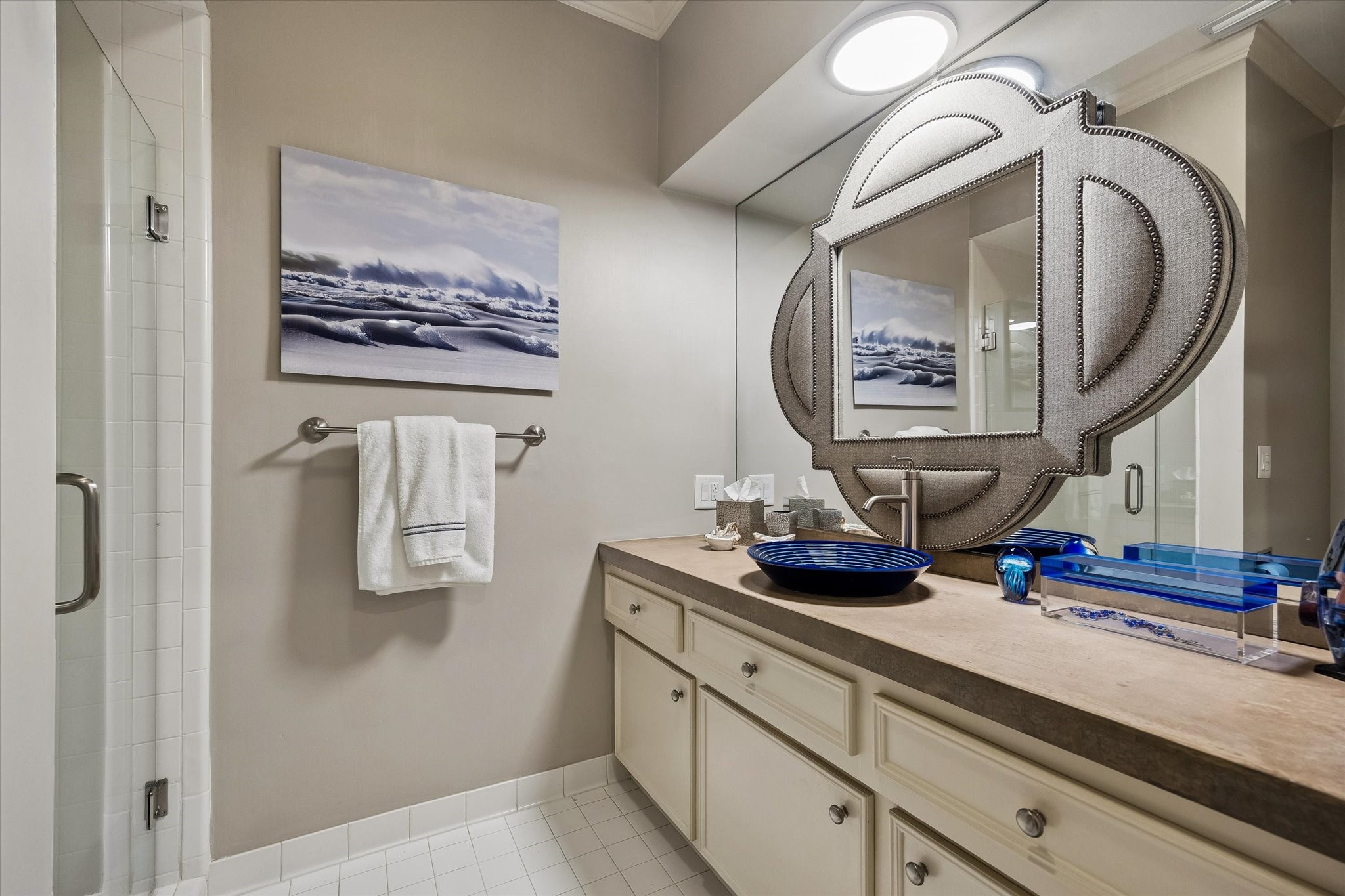 The private en suite Bath features an updated vanity with custom touches and a stall shower with a seamless glass door.