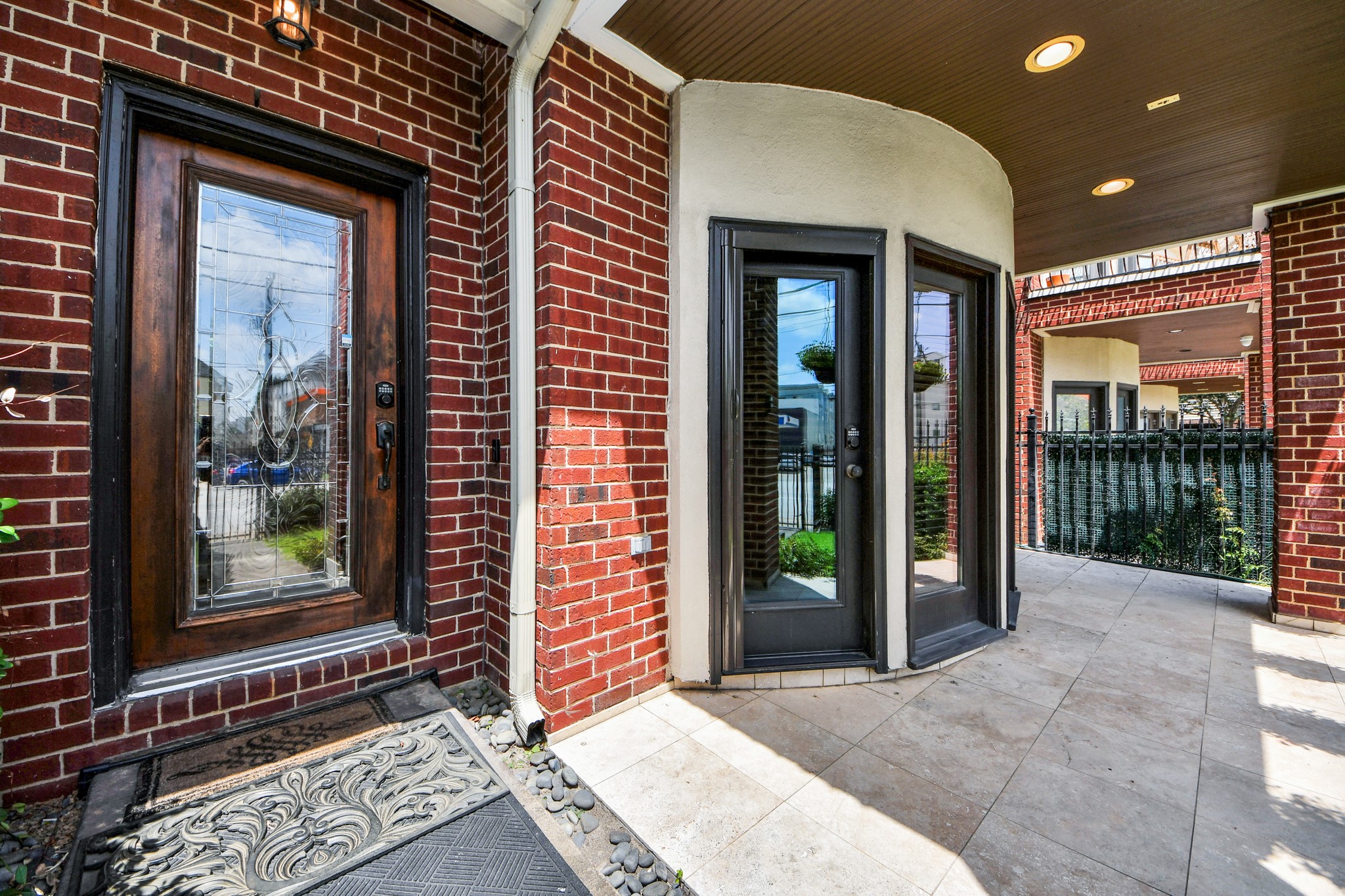 Charming brick entryway with elegant glass doors and a covered patio, offering a welcoming and stylish entrance.