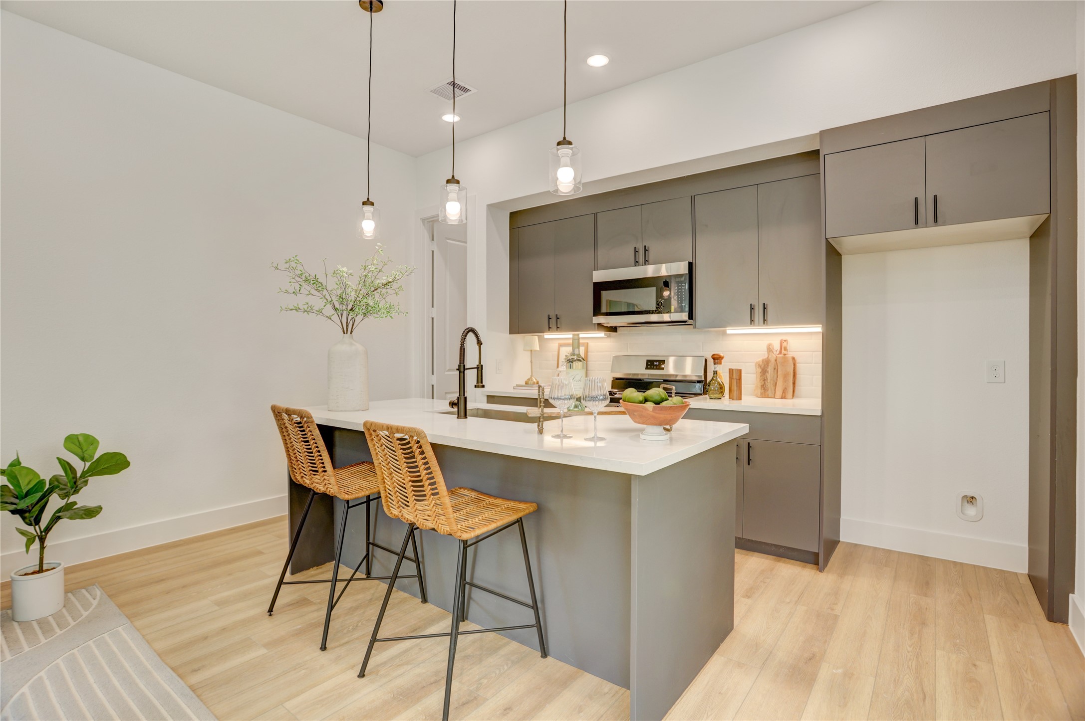 The kitchen has a 5 burner gas stove, under cabinet lighting, and stone tile backsplash.