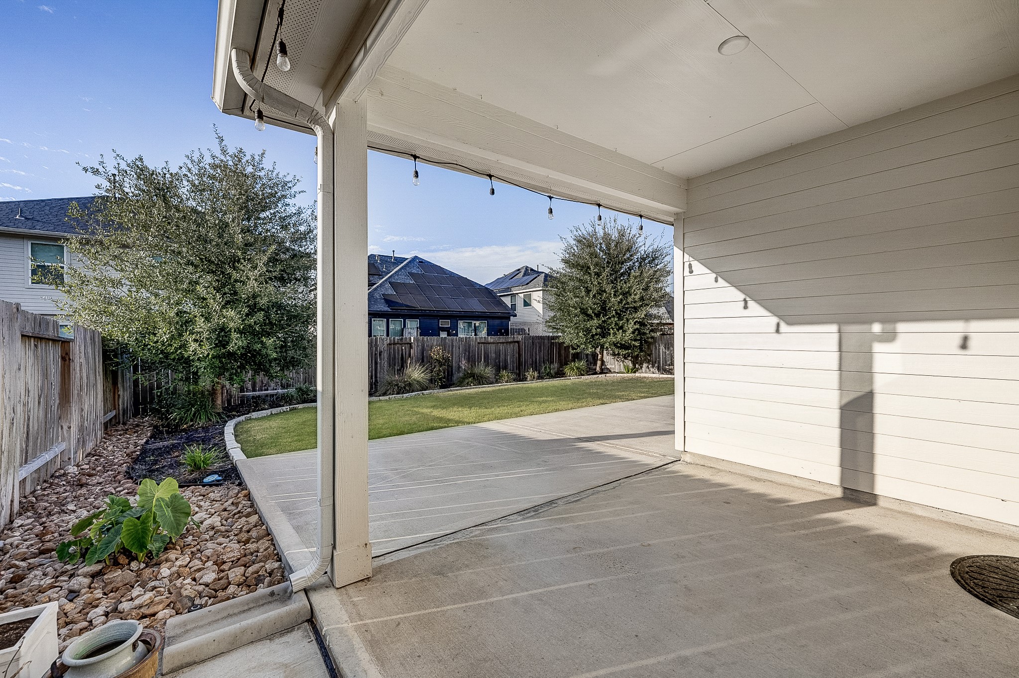 Enjoy outdoor living in this spacious covered patio overlooking a well-maintained backyard, perfect for entertaining or relaxing.