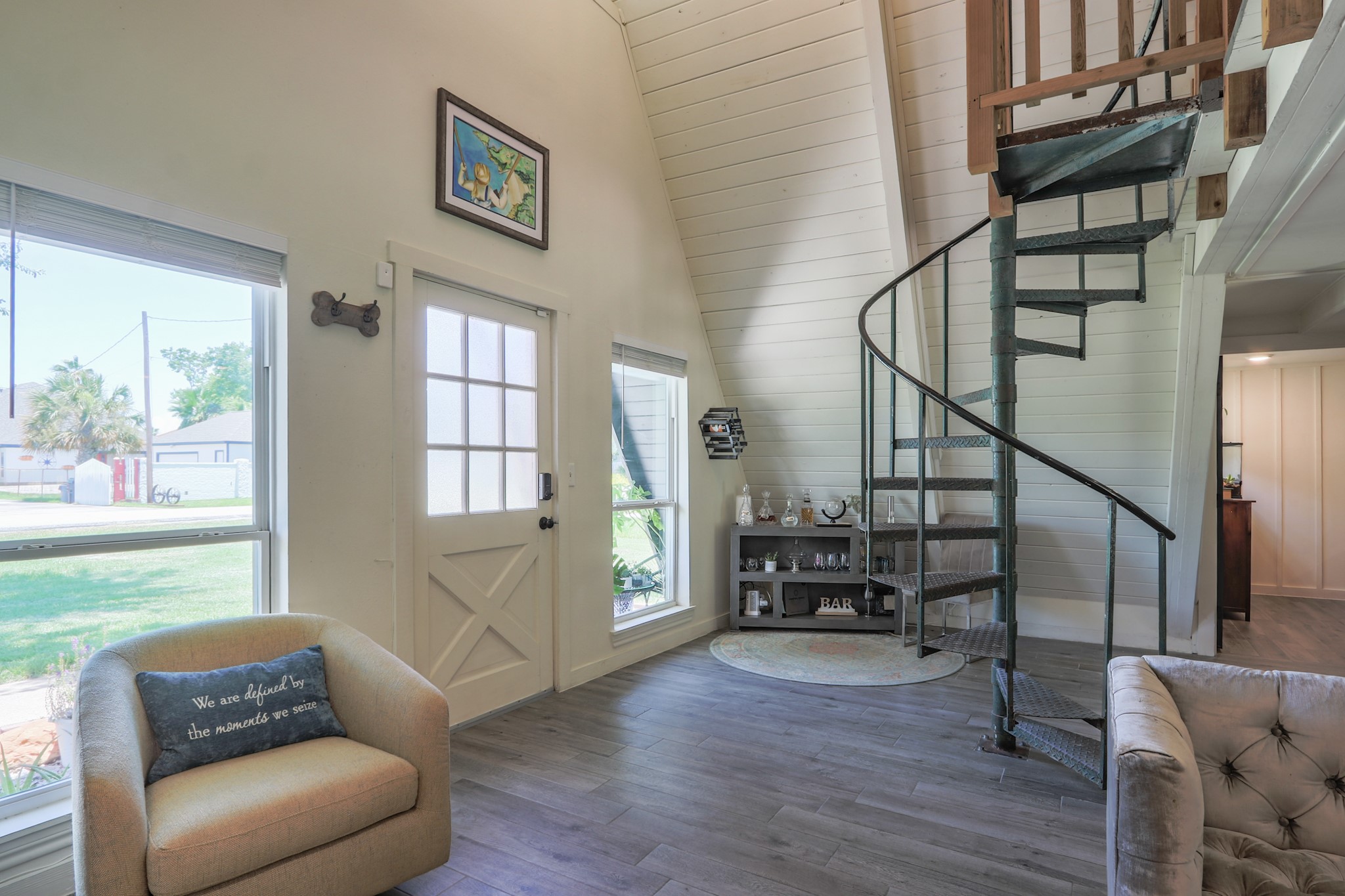 A closer look at the entry and how it is laid out with the staircase.   There is a small sitting space to right and to the left of the front door... The wood look tile floors are in perfect condition and run through the entire home, the color has gray and brown tones in it and will play well with any decor...