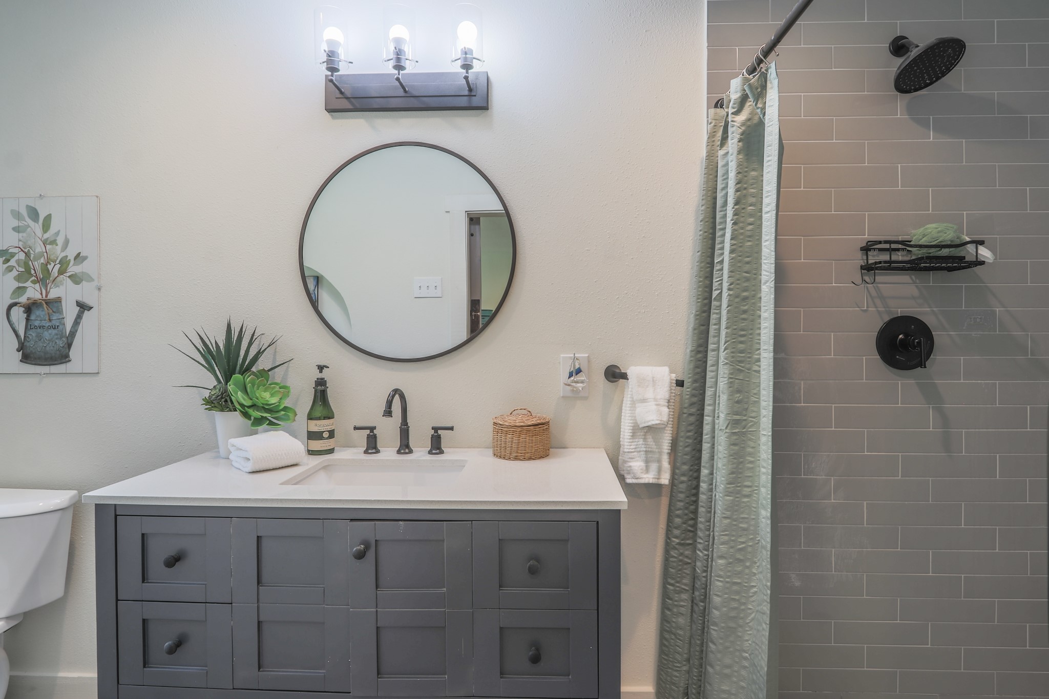 Private bath in second room also has a large custom shower and modern lighting, vanity and mirror.