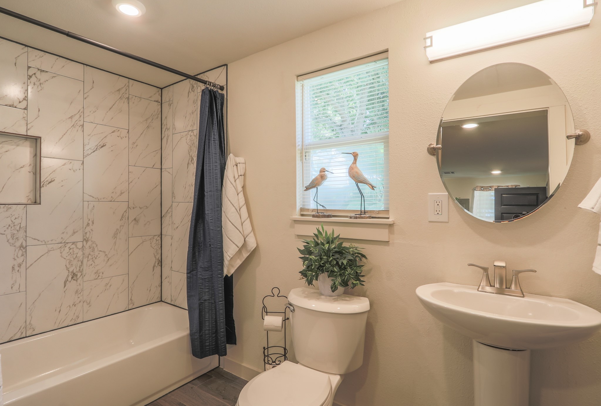 The third bath has a tub and shower combo  as well as updated lighting and sink.   This room has a nice size linen or storage closet as well.