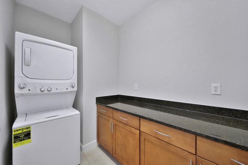 The view of laundry room W/Cabinets and granite counter-tops.