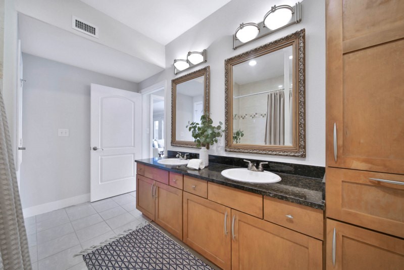 The view of hallway full bath W/Double sinks and granite counter-tops.