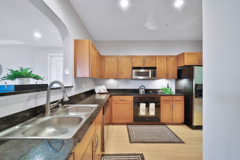 The view of kitchen W/Granite counter-tops, New cooktop and Stainless Steel appliances.