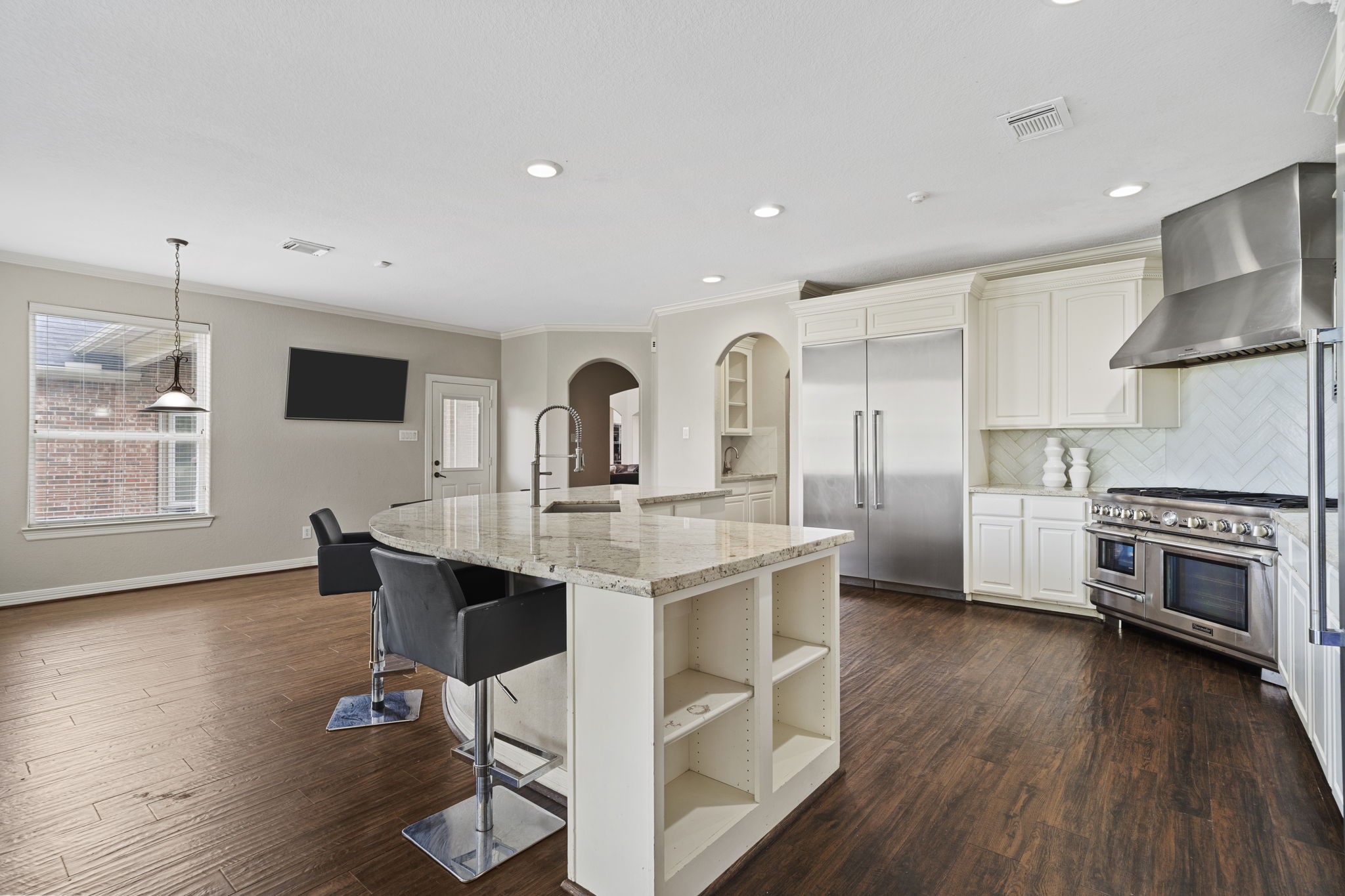 The kitchen opens seamlessly to a casual dining space and expansive living area, creating the perfect setting for everyday relaxation and effortless entertaining.