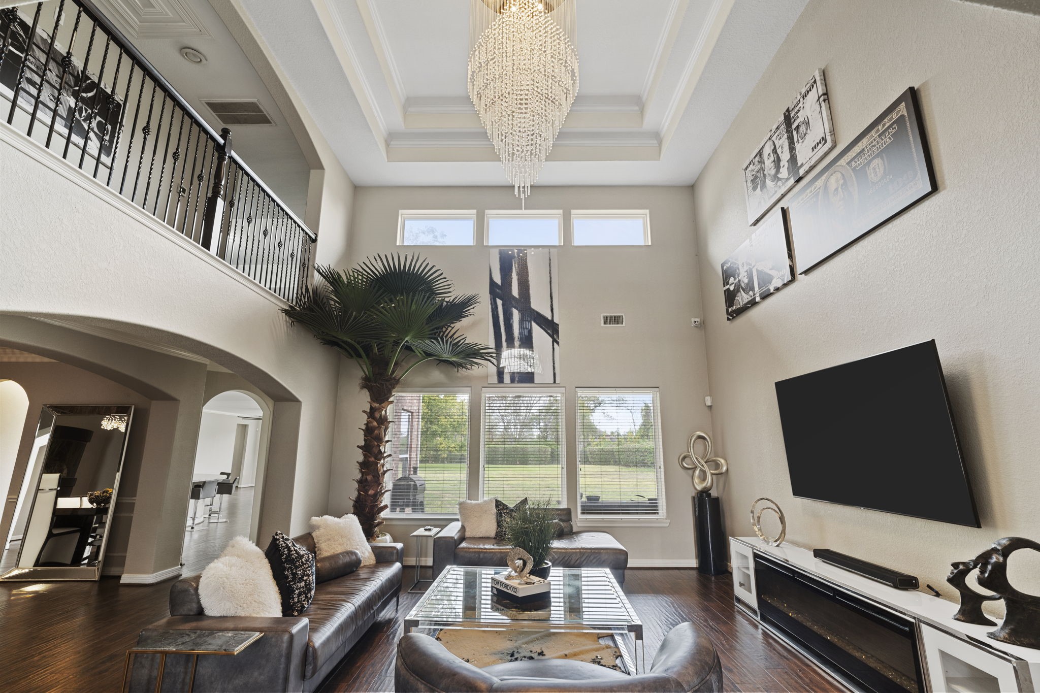 Impressive two-story living room featuring soaring ceilings and a dramatic wall of windows that fills the space with natural light.