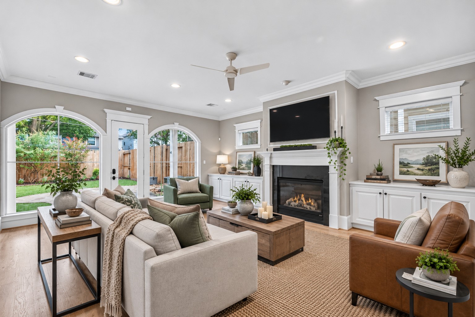 Dramatic arched windows fill the family room with natural light while framing beautiful views of the private backyard and garden. Presented with a different style of decor digitally imagined.