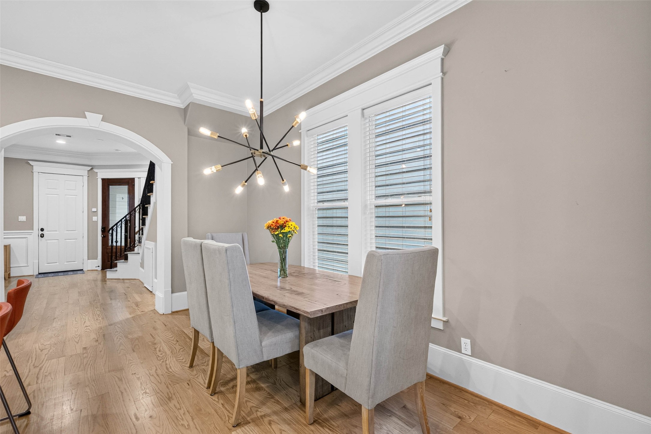 Sunlight, hardwood floors and statement lighting give this intimate dining space a warmth all its own.