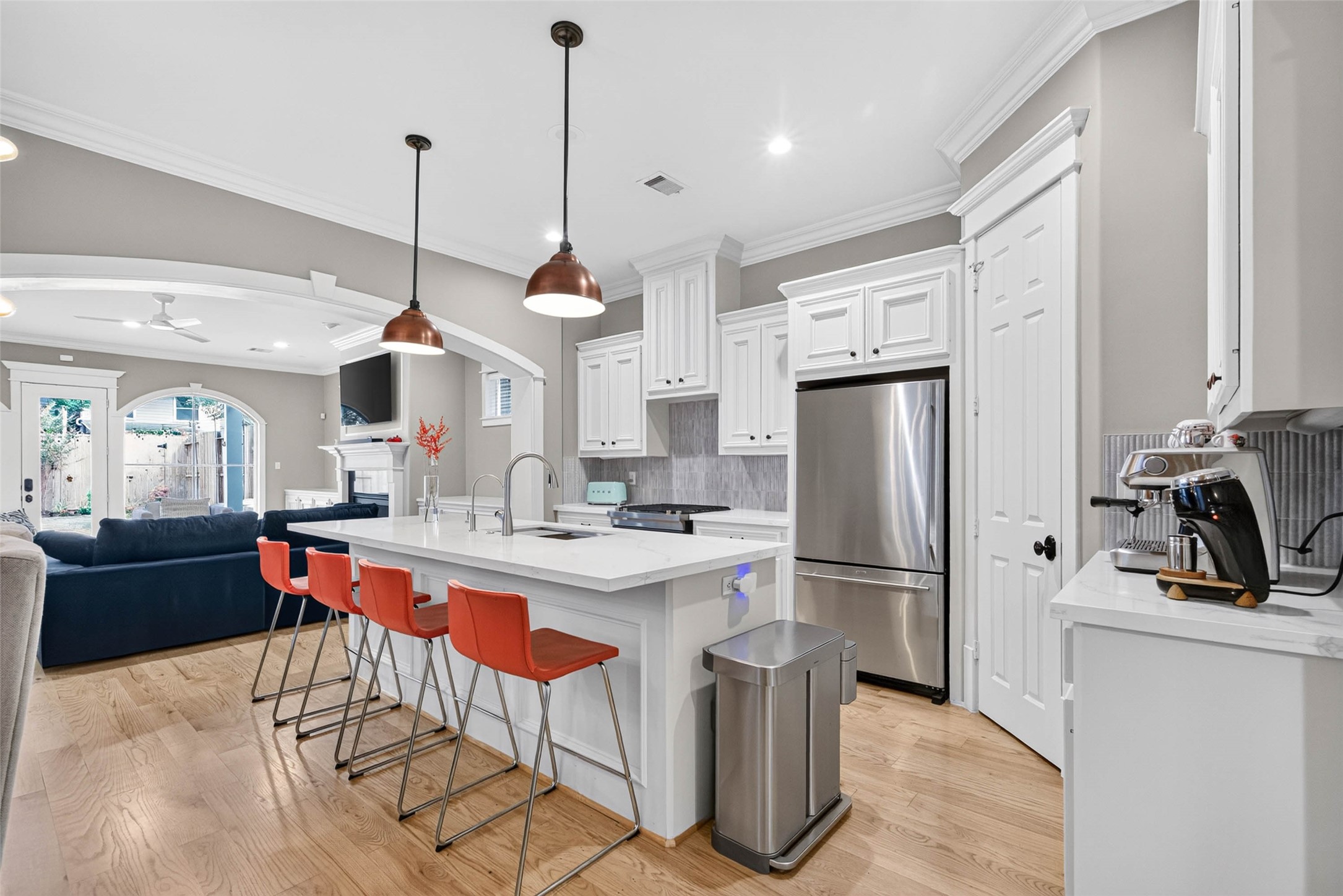 An oversized island anchors the kitchen, offering generous prep space, seating for four and a welcoming gathering place.