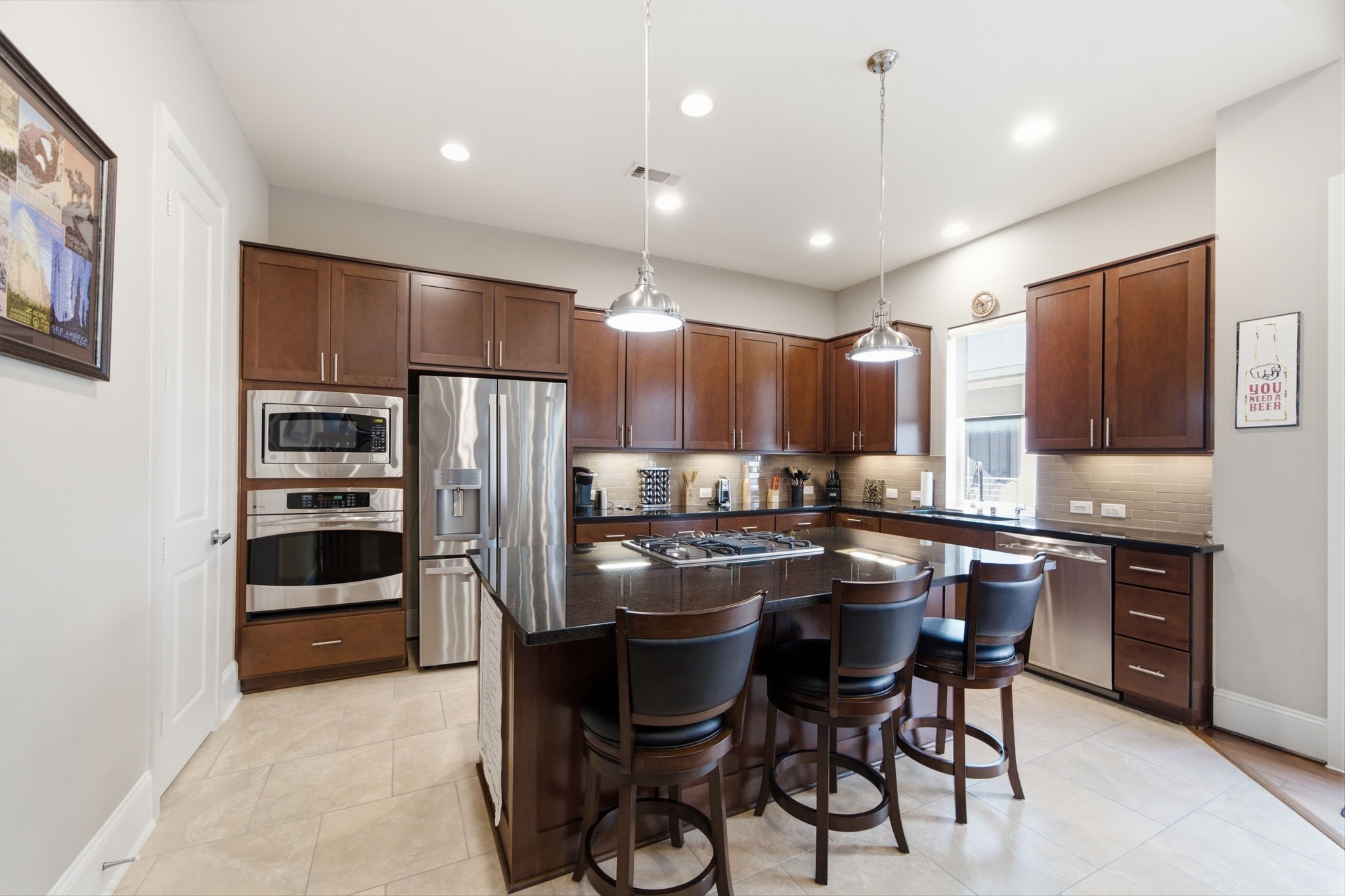 The chef-inspired kitchen features gleaming stainless steel appliances, granite and countertops, and abundant workspace.