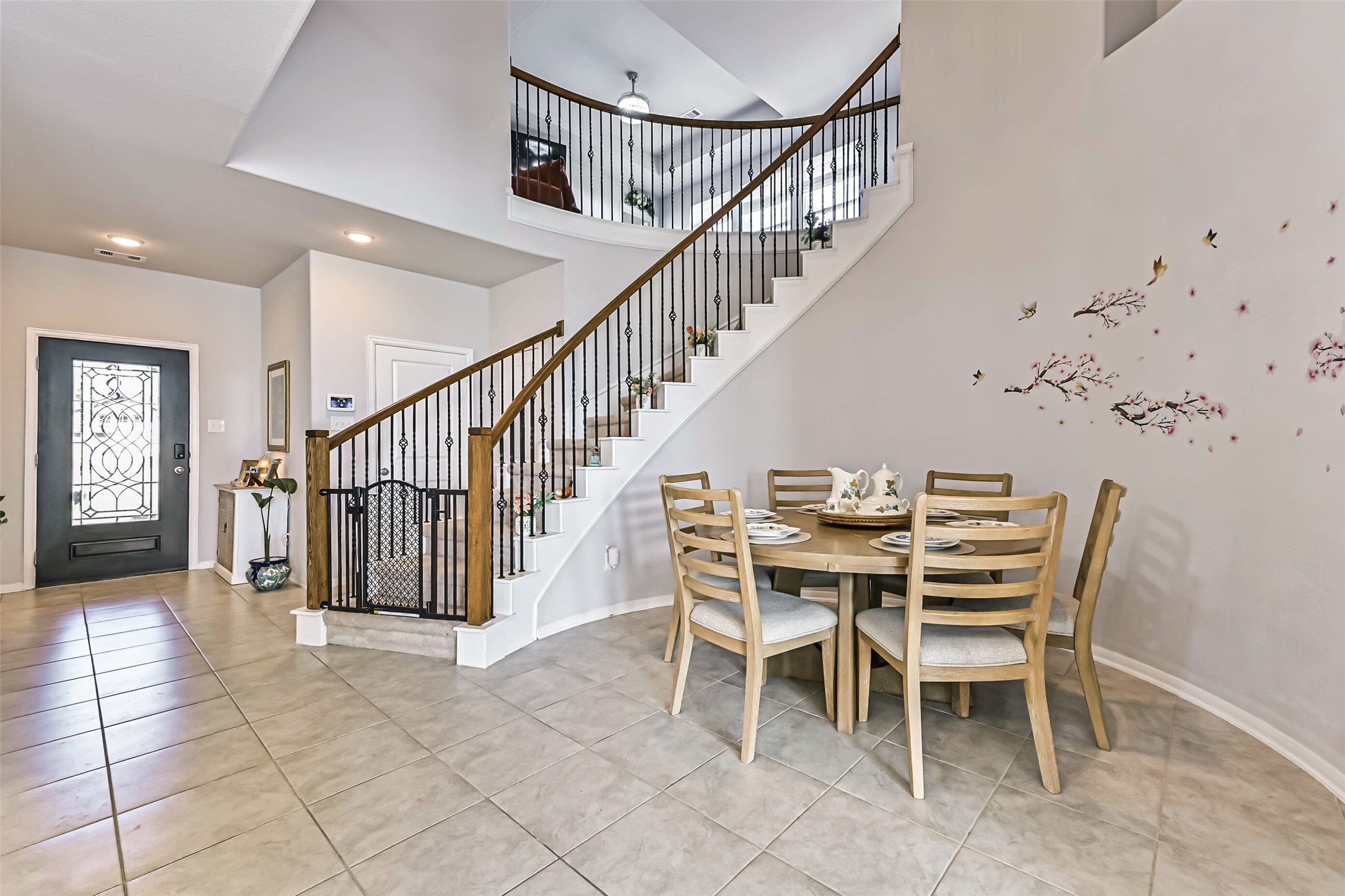 Charming dining area highlighted by a beautiful, curved staircase with wrought-iron detailing, creating an inviting space for everyday meals and gatherings.