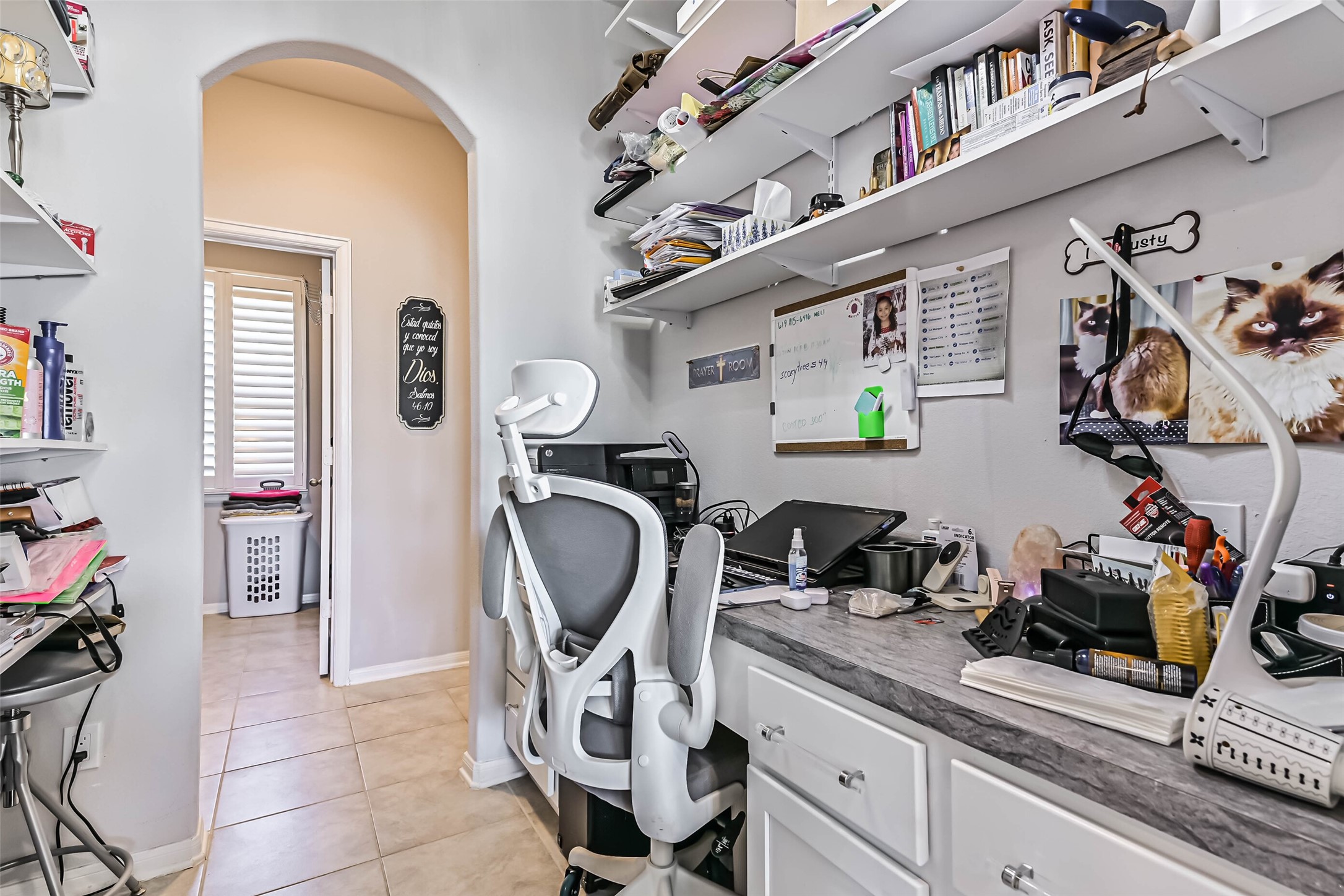 Convenient built-in workspace off the kitchen with countertop, cabinetry, and open shelving, ideal for a home office or household organization.