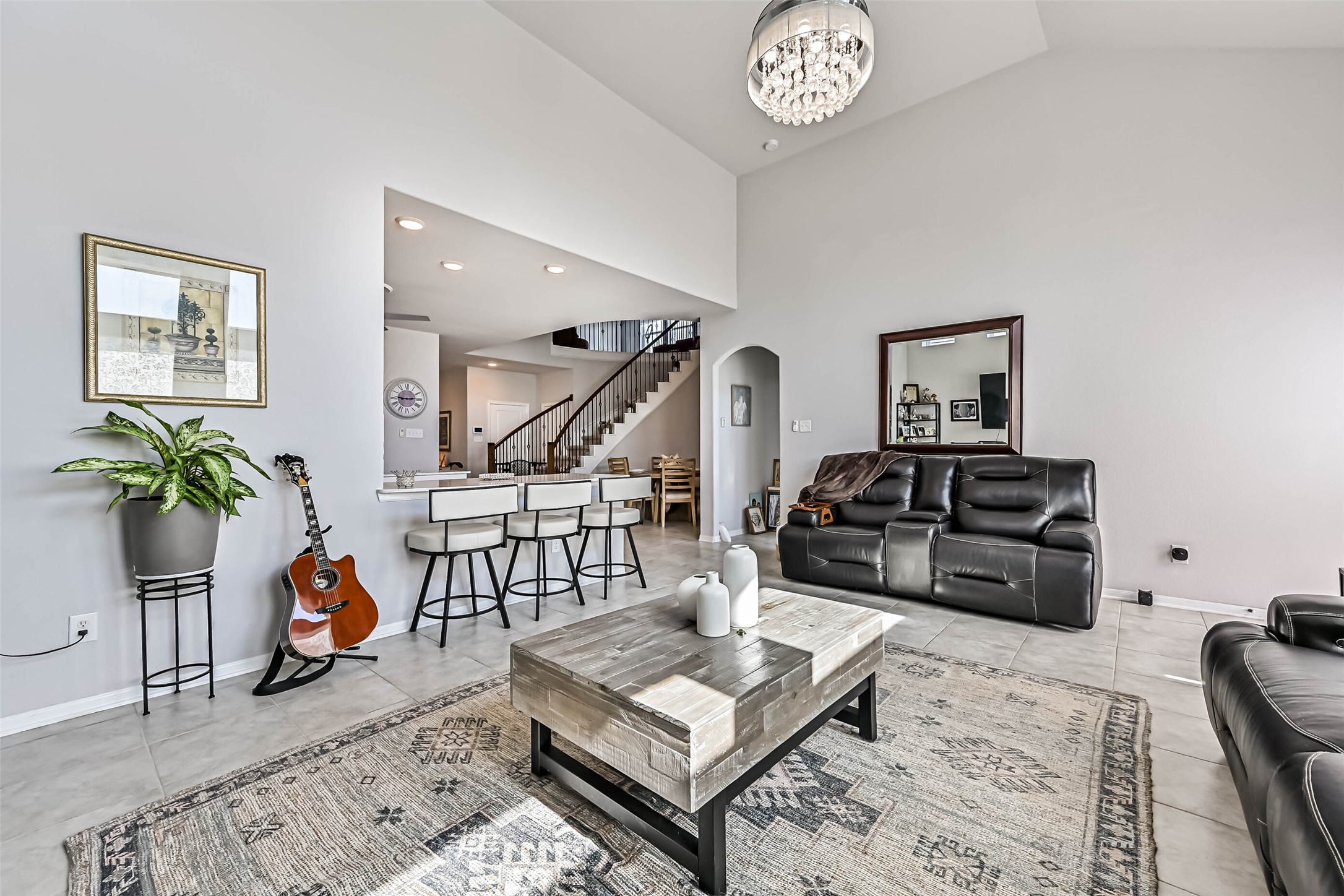 Additional living room view highlighting the open floor plan, high ceilings, and convenient access to the kitchen and dining area.