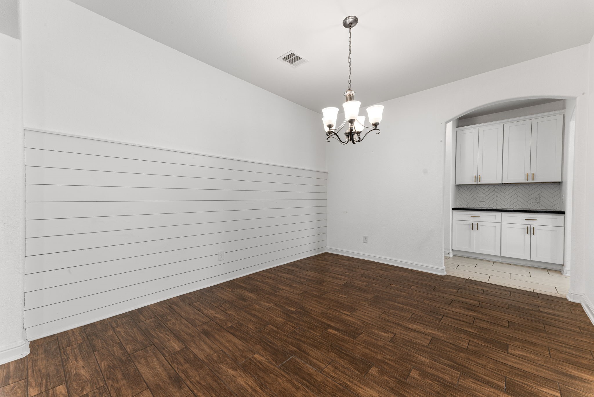 Host dinner parties or enjoy a weeknight meal in this formal dining area with a shiplap accent wall, chandelier and built-in white cabinetry that gives you style and storage in one.