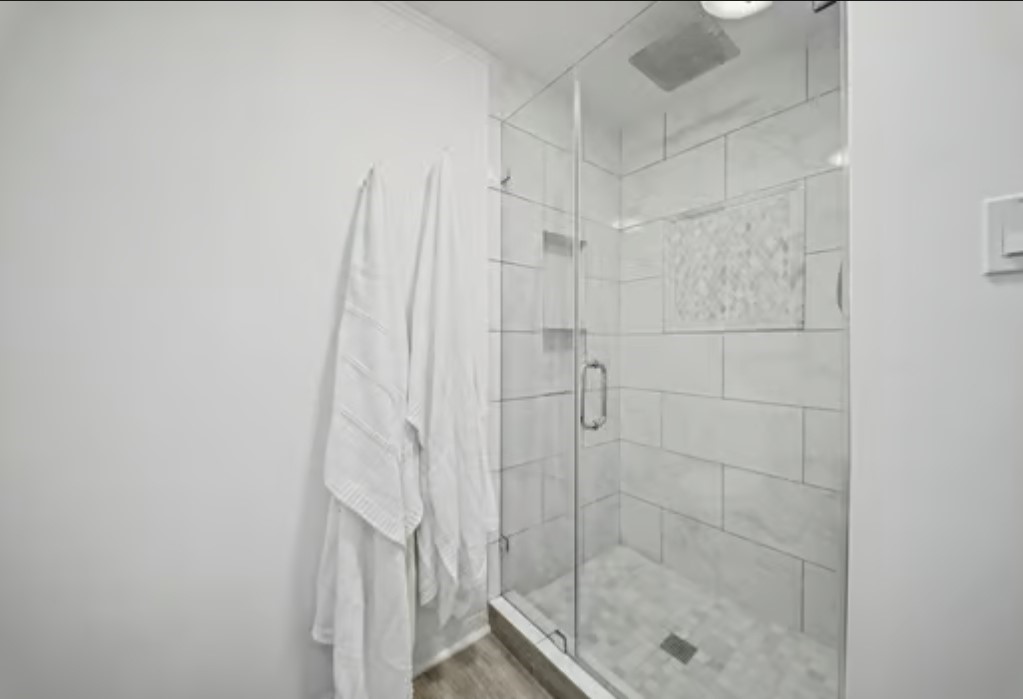 Sleek, modern shower with glass doors and elegant tilework offers a refreshing retreat.
