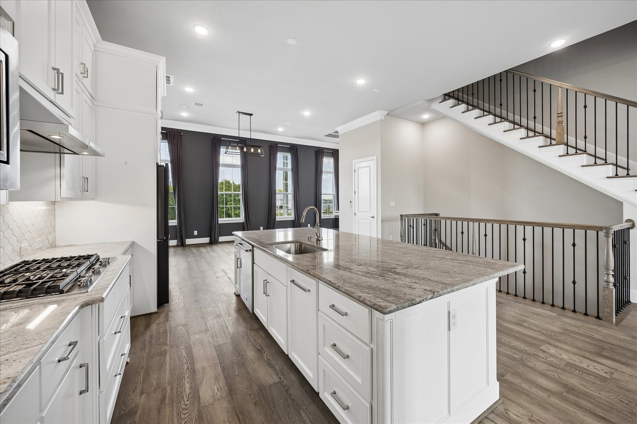 Designed to impress, the kitchen features generous prep space, premium appliances, abundant cabinetry, and a large island that serves as a natural gathering place for family and guests.