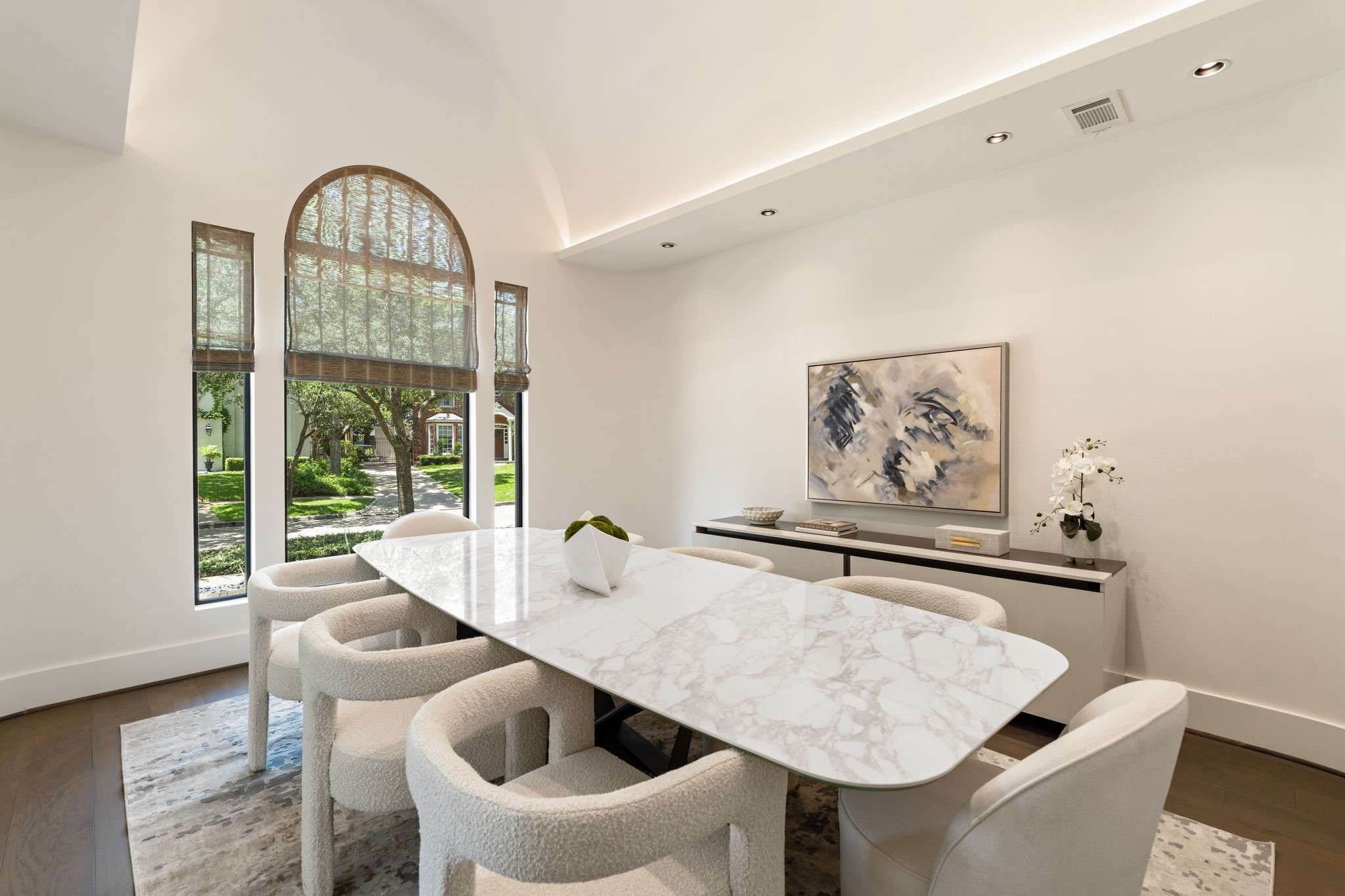 Elegant formal dining room with soaring ceilings, dramatic arched windows, and abundant natural lightan inviting space designed for intimate dinners and memorable celebrations.