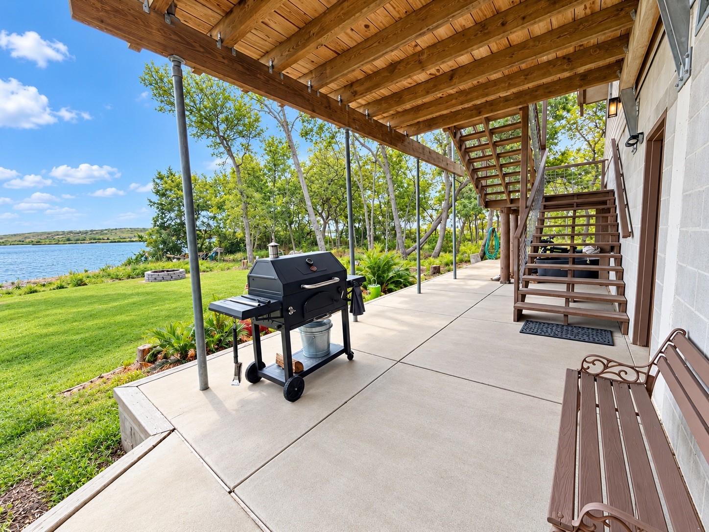 Enjoy serene lakeside views from this spacious patio, featuring a covered area perfect for outdoor entertaining.