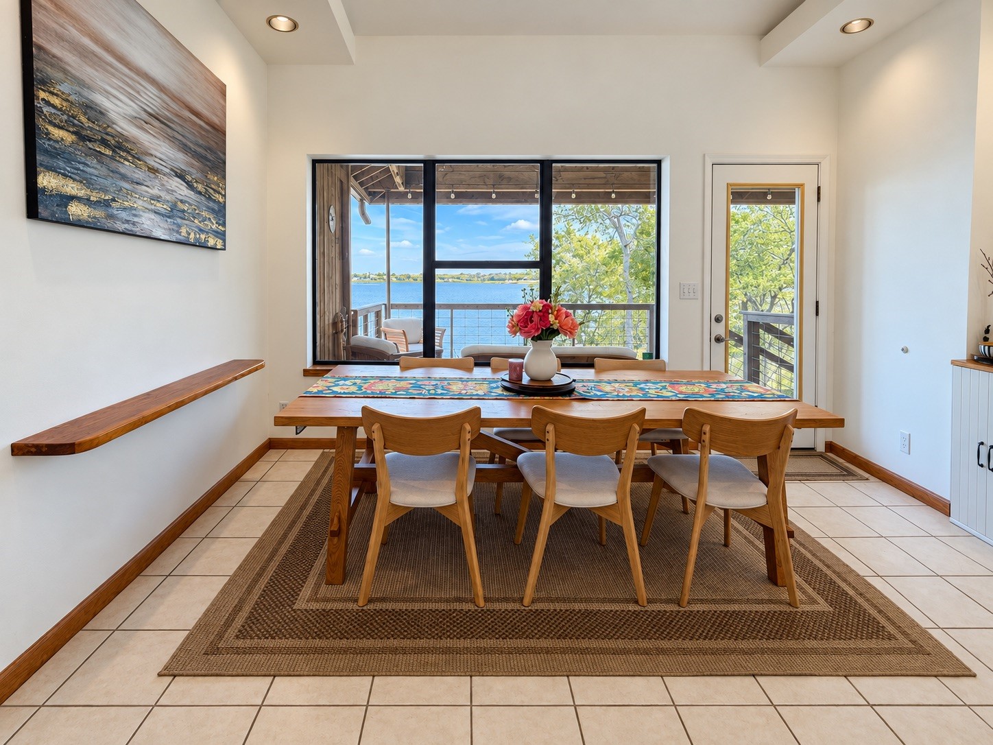 Bright dining area with stunning lake views through large windows.