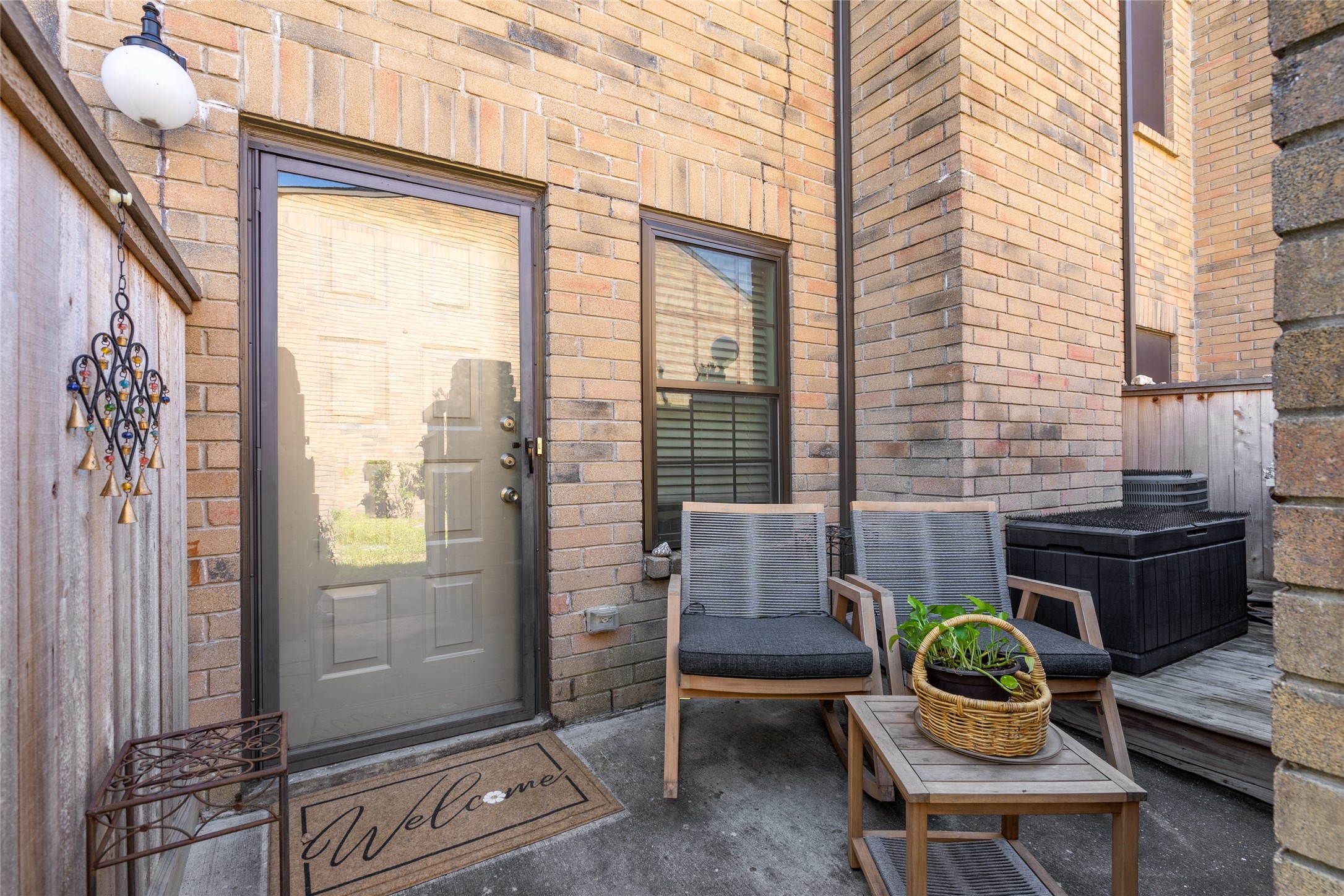 Charming and private, this inviting front patio offers the perfect space to enjoy your morning coffee or unwind in the fresh air. Featuring a cozy seating area, stylish brick exterior, and a welcoming glass door entry, this space sets the tone for comfortable living. A touch of greenery and decorative accents add to the warm and inviting ambiance.