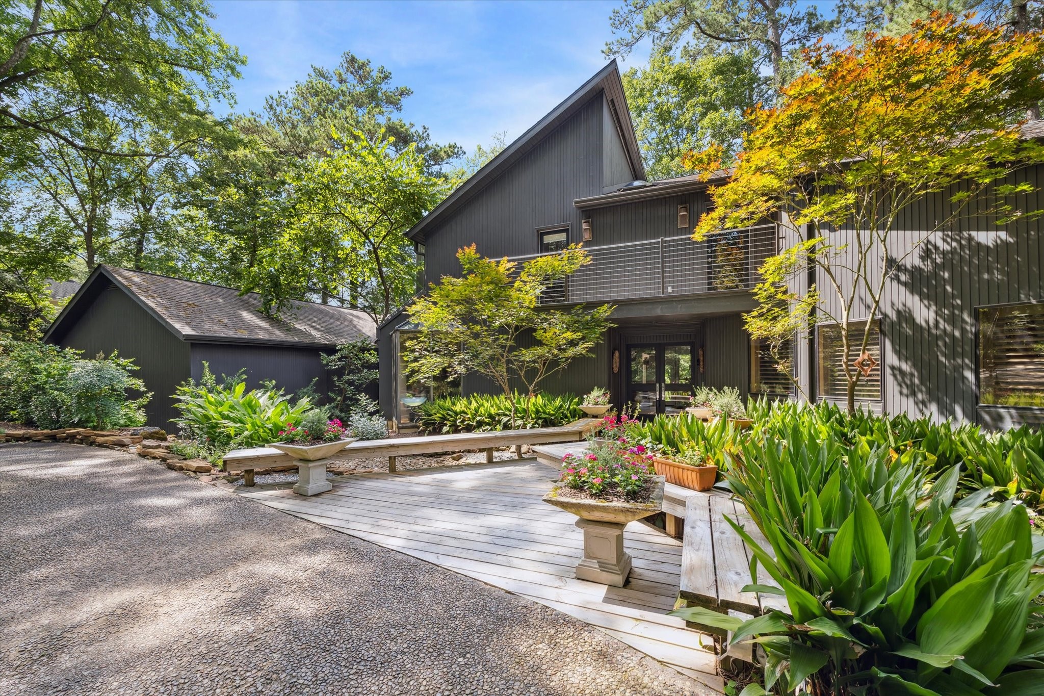 Lush landscaping, mature plantings, and a serene courtyard approach create a warm and inviting arrival. This unique property combines modern design with a peaceful retreat-like atmosphere, offering both style and privacy in a natural setting. Lush landscaping, mature plantings, and a serene courtyard approach create a warm and inviting arrival. This unique property combines modern design with a peaceful retreat-like atmosphere, offering both style and privacy in a natural setting.