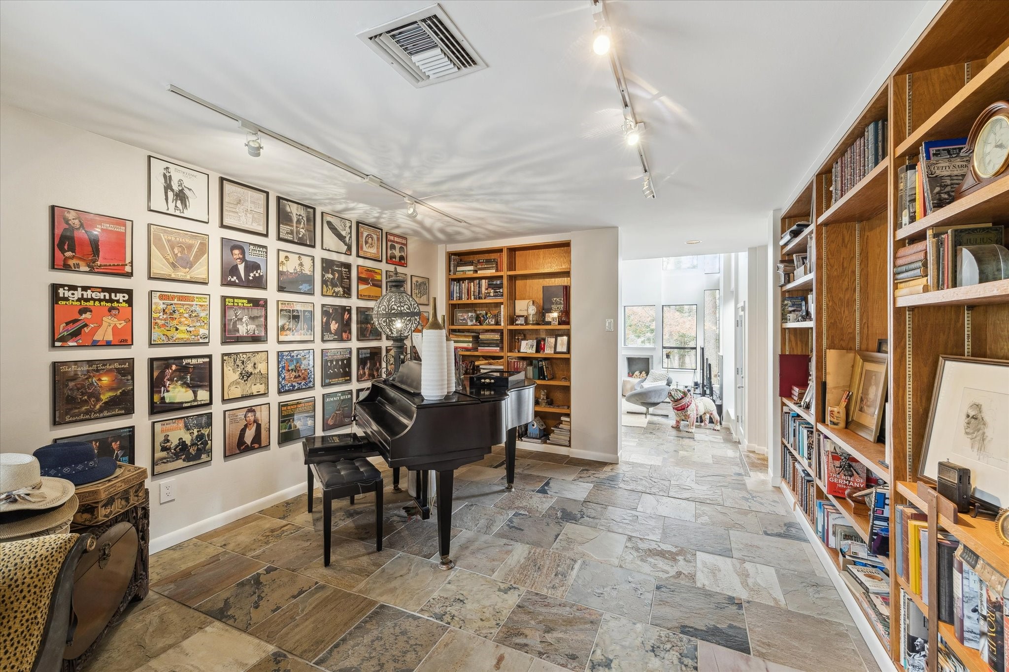 Versatile room currently used as a music room, featuring floor-to-ceiling built-in bookshelves also lends itself well to use as a private study/home office, or a library.