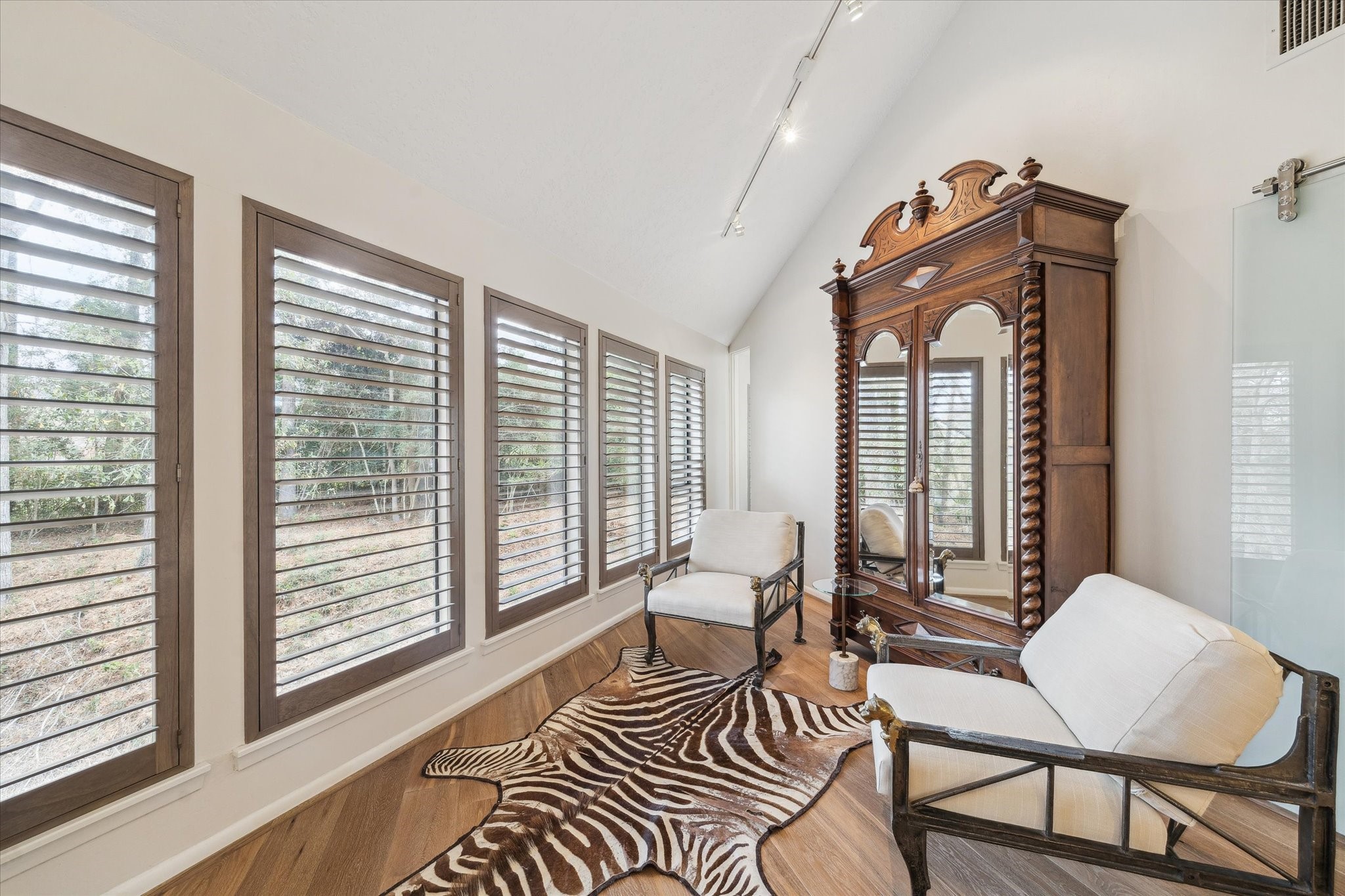 Charming seating nook within the primary bedroom, perfectly positioned to overlook the wooded backyard and create a serene refuge for morning coffee or evening relaxation.