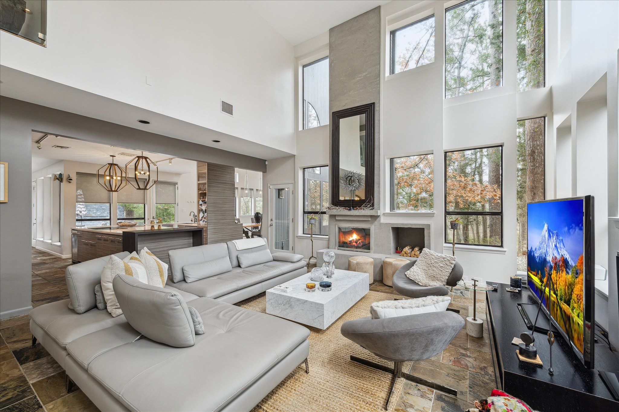 Incredible floor-to-ceiling windows frame sweeping views of the propertys natural surroundings, filling the home with abundant natural light.