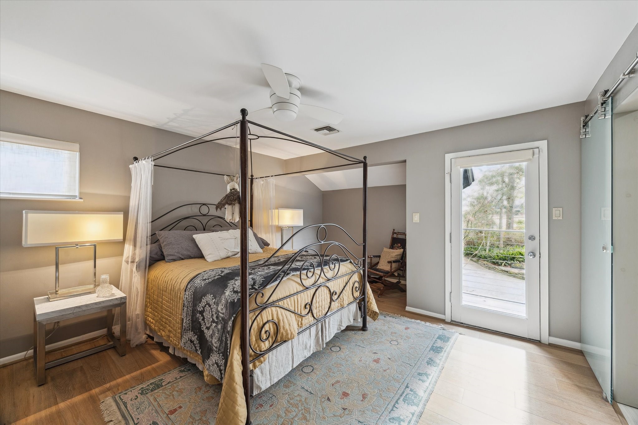 Secondary bedroom with balcony access, tranquil treetop views, and convenient connection to the Jack & Jill bath.