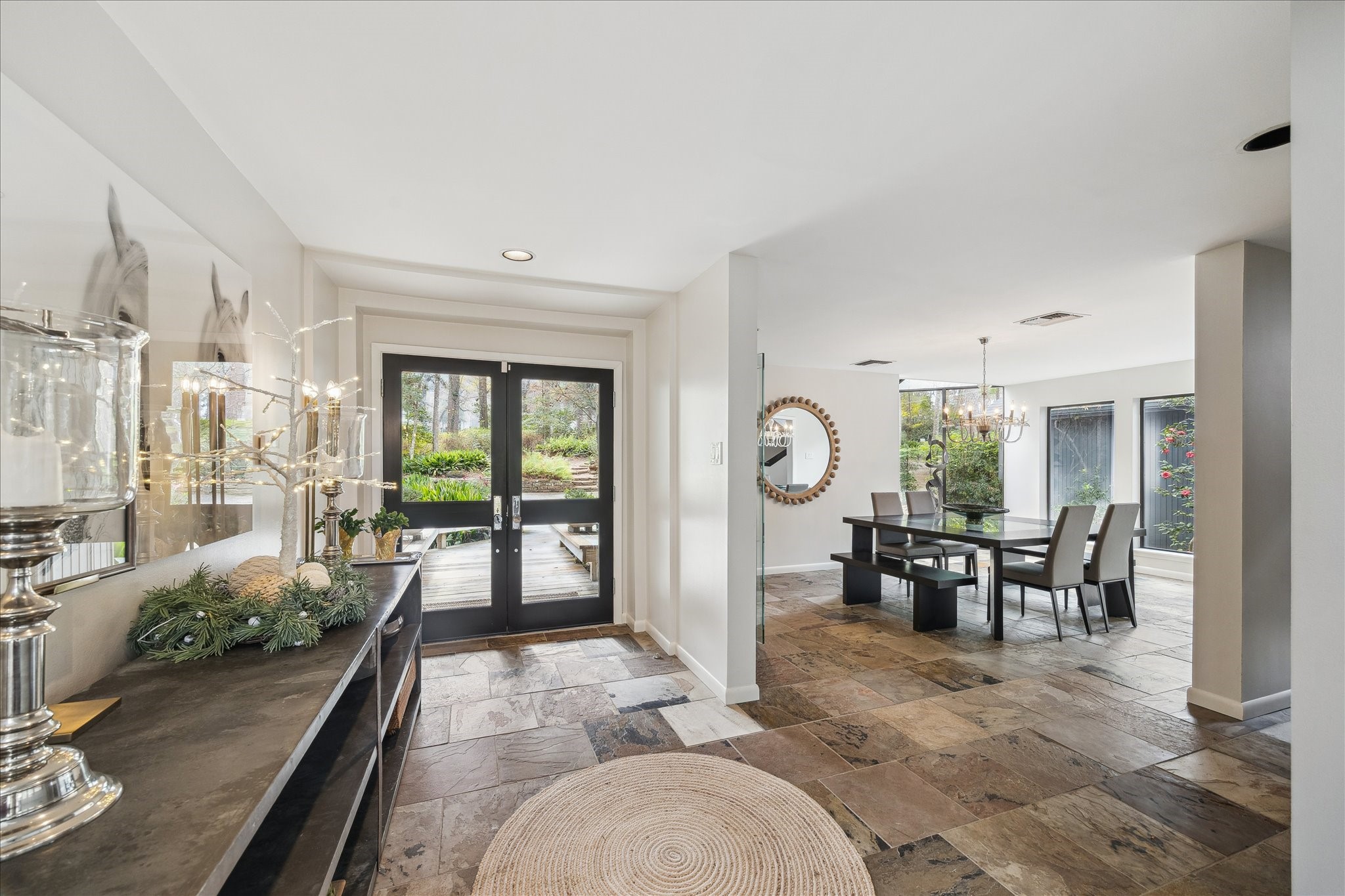 Welcome guests through the glass-inlaid double doors into a raised grand entryway, where abundant natural light, elegant architectural details, and a welcoming sense of arrival set the tone for the home.