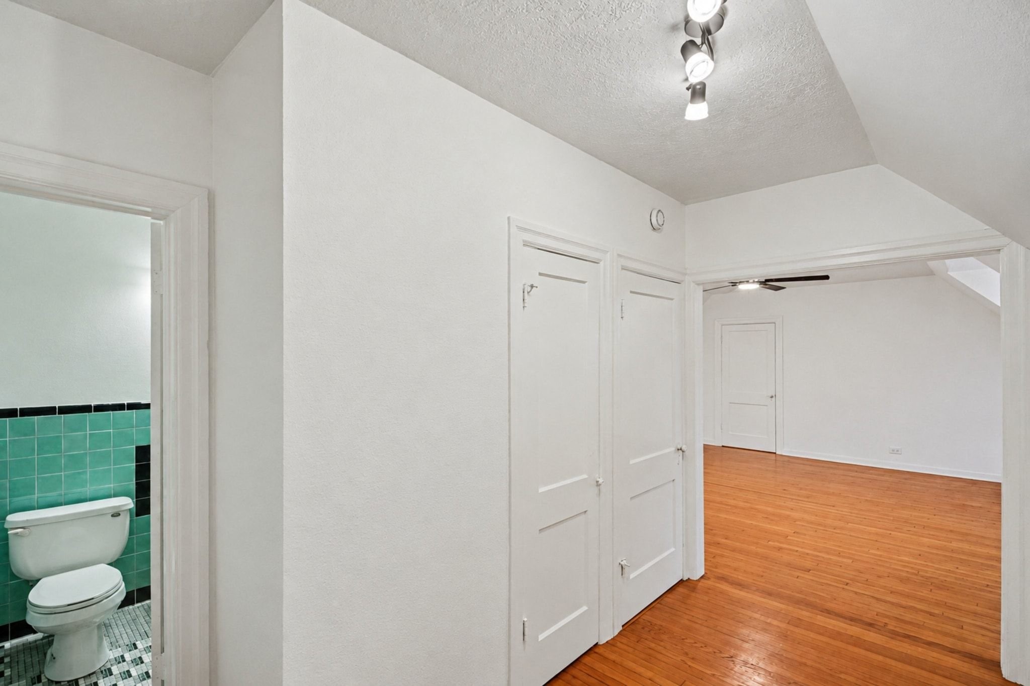 Upstairs second primary suite has a large hallway leading to the en suite full bath.