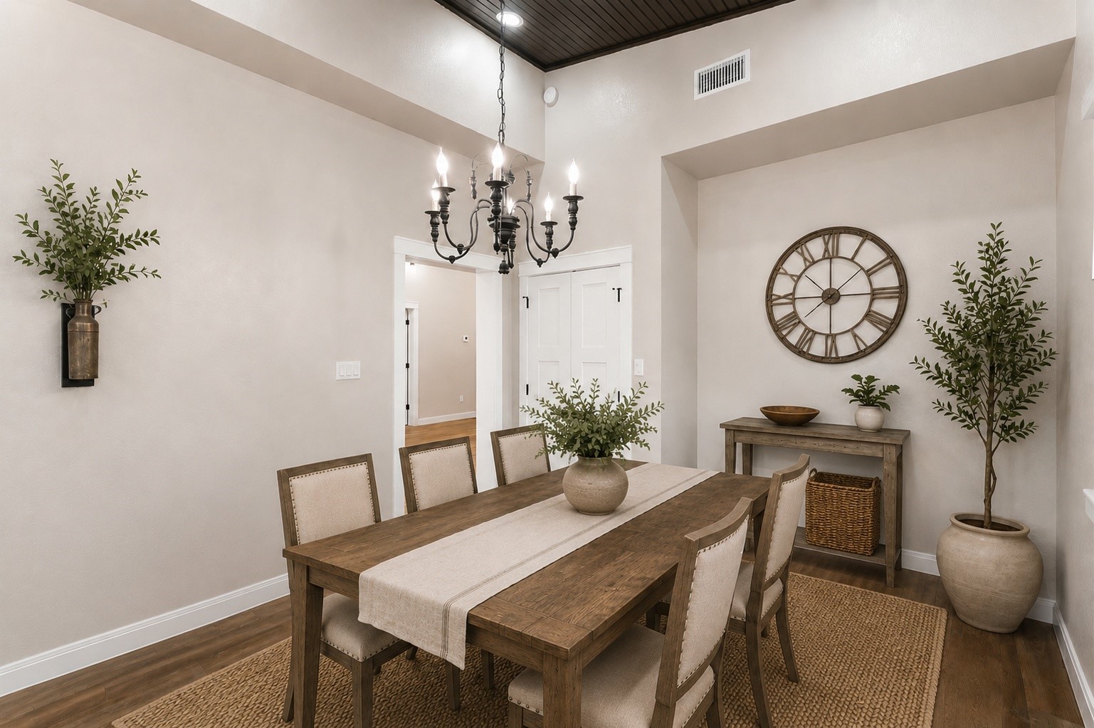 This room can be used as dining or a bonus room with the elegant tile flooring and soft taupe walls, accented by a classic chandelier. The space is finished with white trim and double doors, creating a welcoming entryway.
